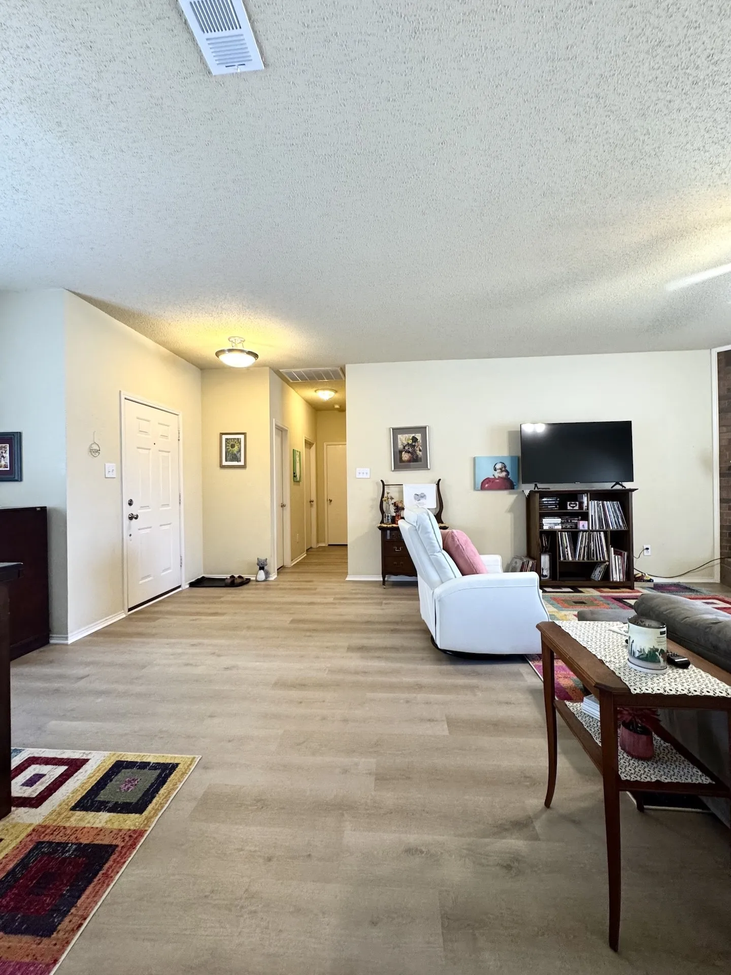 Expansive room with wood-finish flooring, recessed ceiling lighting, and a neutral wall palette