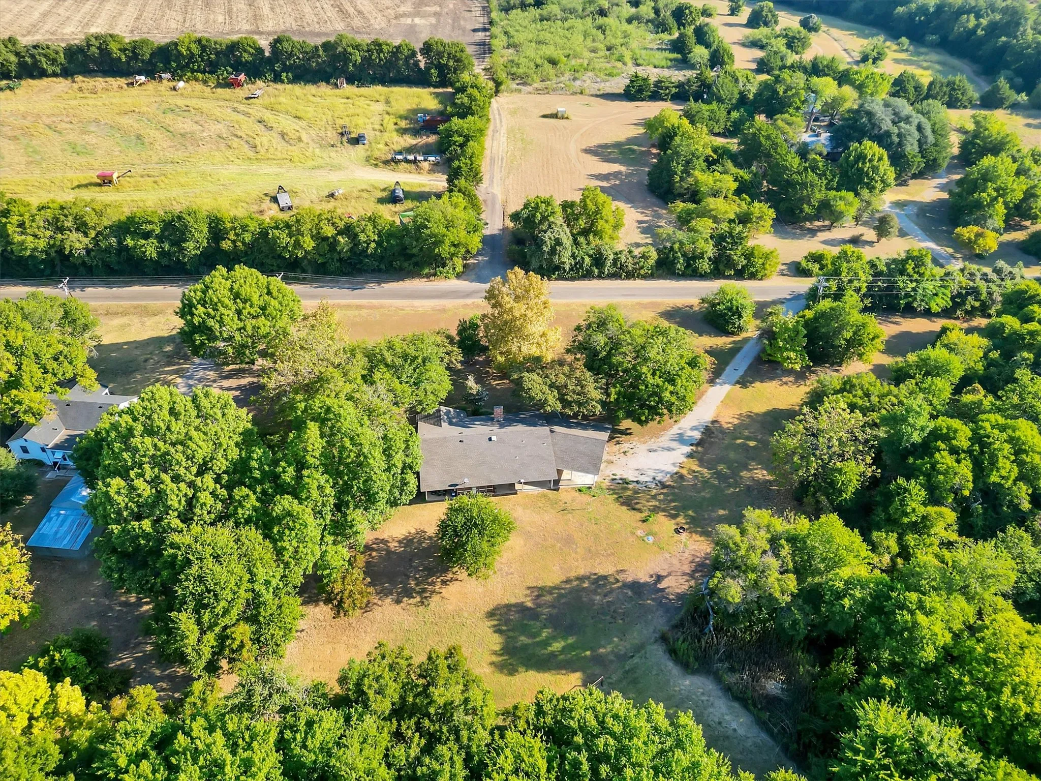 Expansive property featuring a single-story residence, mature trees, a private driveway, and an in-ground pool