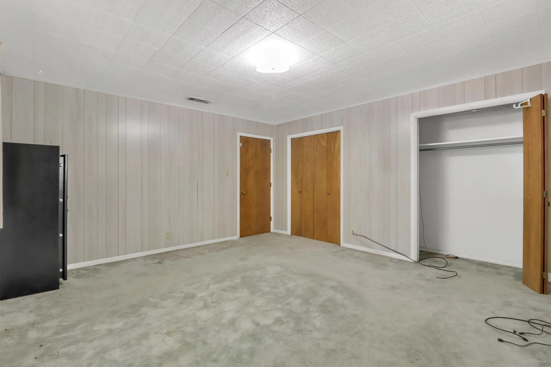 Wall paneling, ceiling paneling, flush mount ceiling light fixture, wood-finish doors, built-in closet with shelving