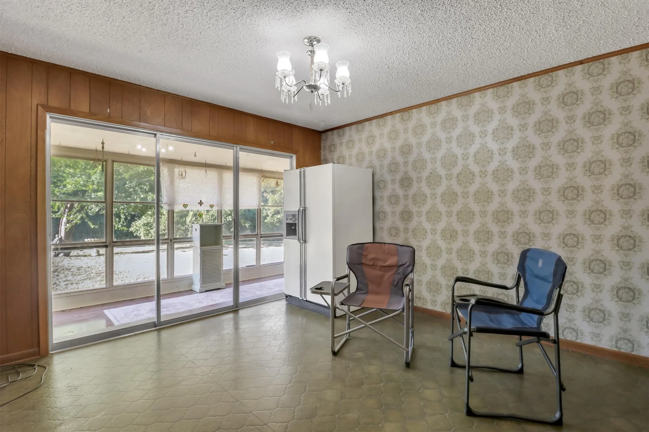 Sliding glass doors, textured ceiling, decorative wallpaper, wood paneling