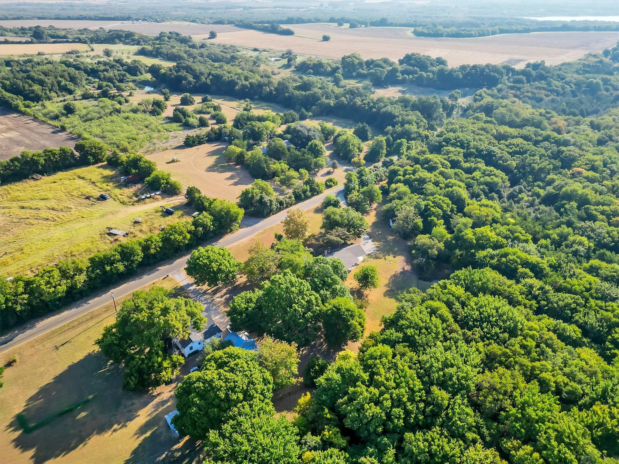 Expansive acreage featuring mature trees and a paved road frontage