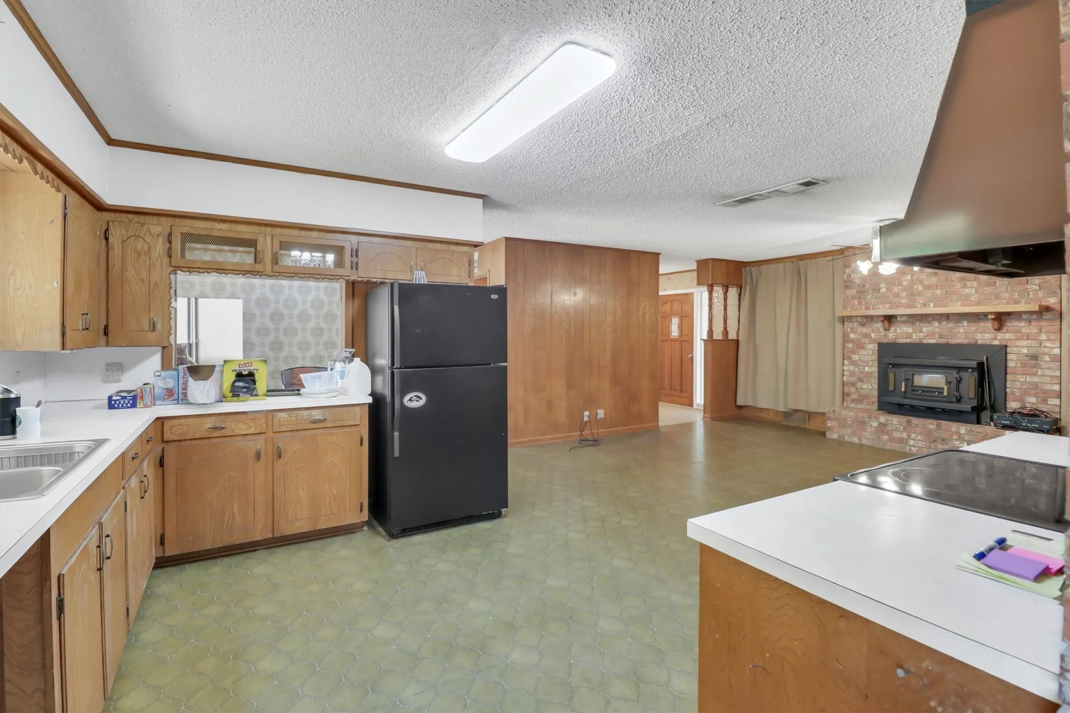 Kitchen featuring wood-finish cabinetry, integrated sink, and white countertops