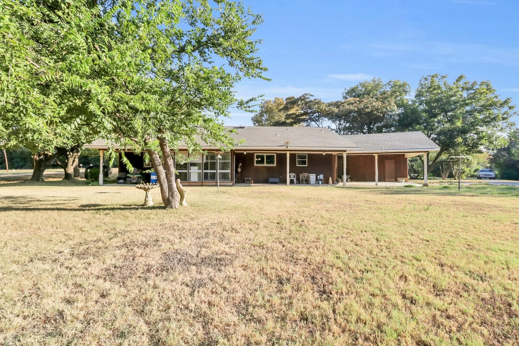 Expansive backyard with a sloped lawn and mature trees