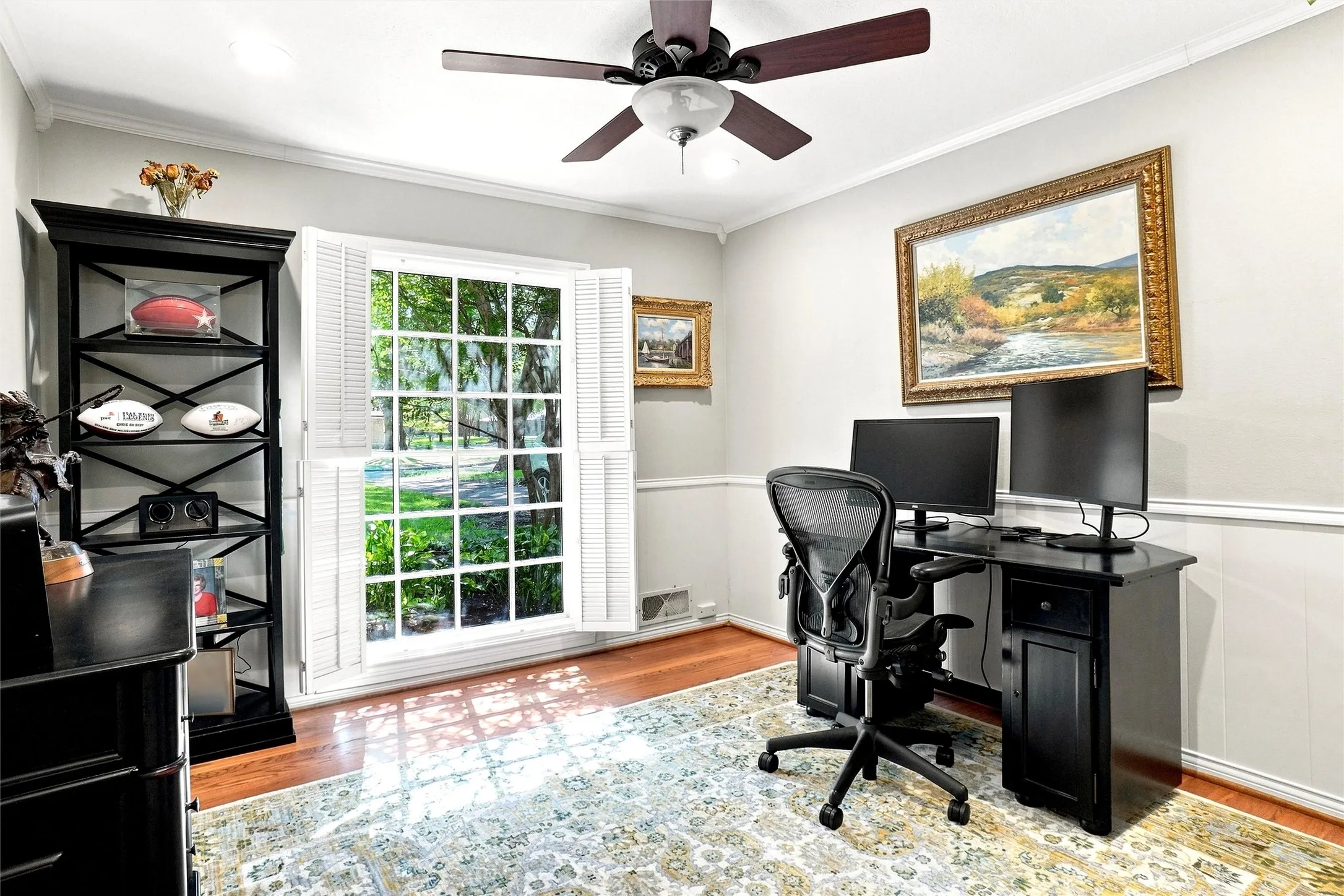 This is the 2nd bedroom downstairs that is in the front of the home. A big beautiful window, ceiling fan, crown molding, chair rail, and wood flooring are found here.  Currently used as an office. All of the bedrooms have walk=in closets.