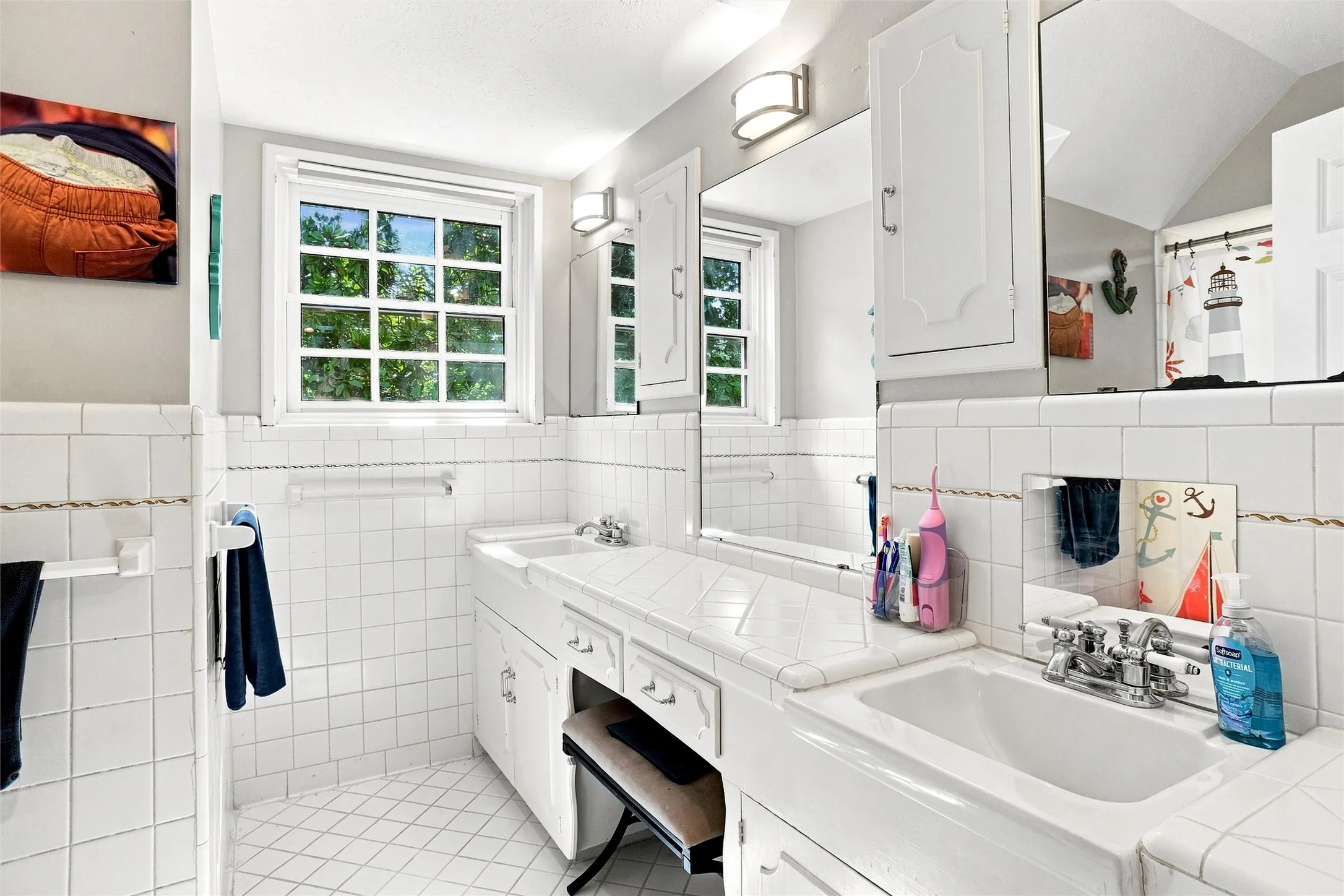 The hall bath upstairs is quite generous in size and offers 2 sinks, lots of storage, and  a tub/shower combination.The Mid-Century Modern  Influences have been wonderfully preserved in this area! Just charming.