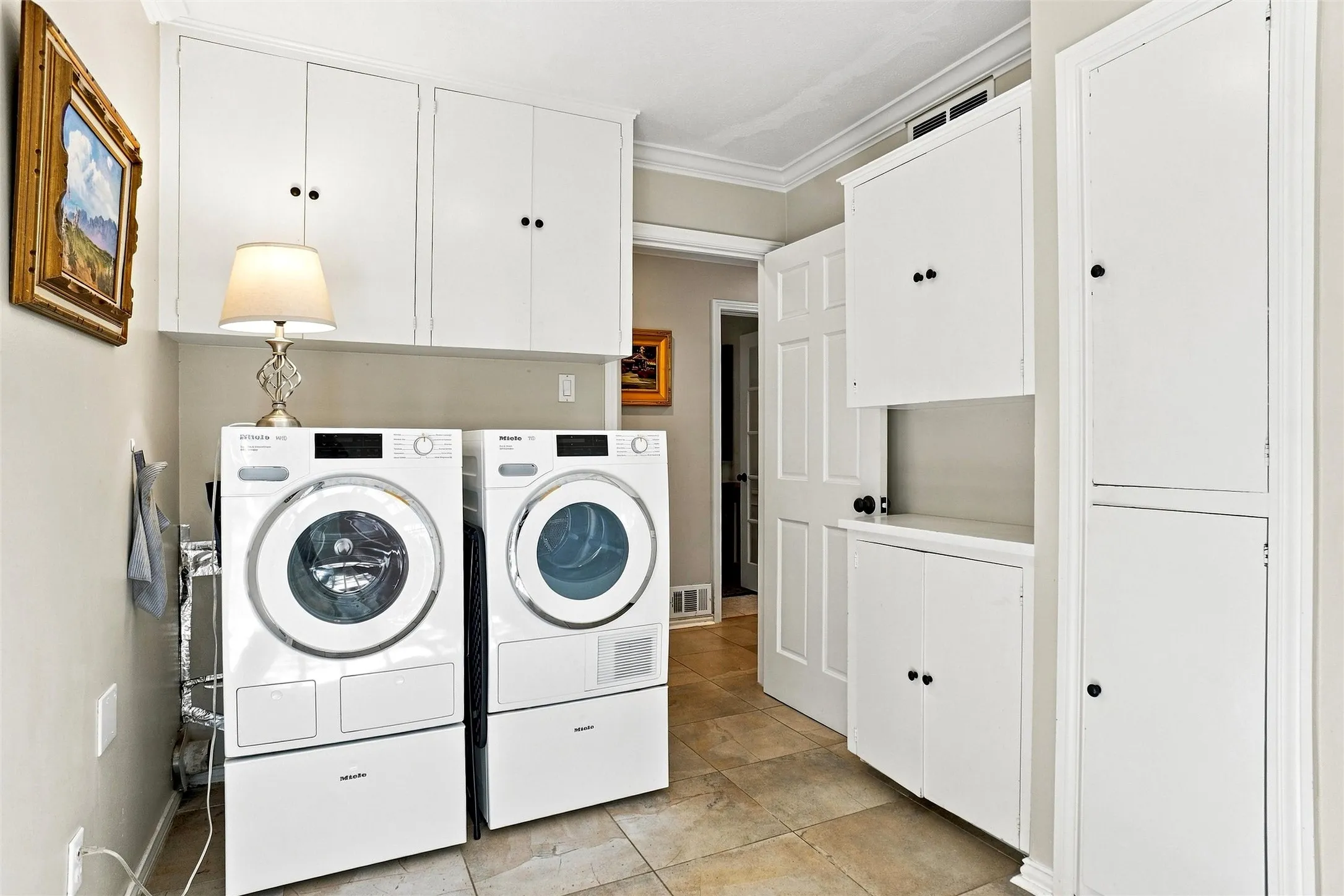 This laundry room is a dream! There is storage galore and even a large cabinet that could serve as a second pantry if desired. There is also a closet pantry on the opposite wall to the washer and dryer. Lots of storage and just a gem of a laundry room.