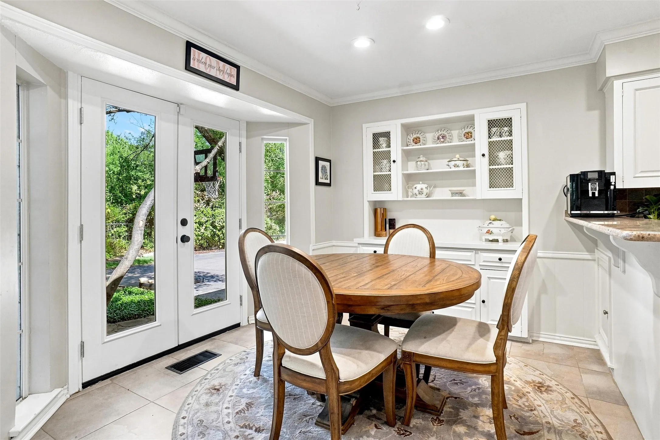 This home has many built-ins throughout which totally elevates the feel of the home .The built in hutch in the background adds not only additional storage but also  character to the room.  The wall of windows and doors add so much natural light to the home for a bright cheery living environment. Note the chair rail and crown molding.