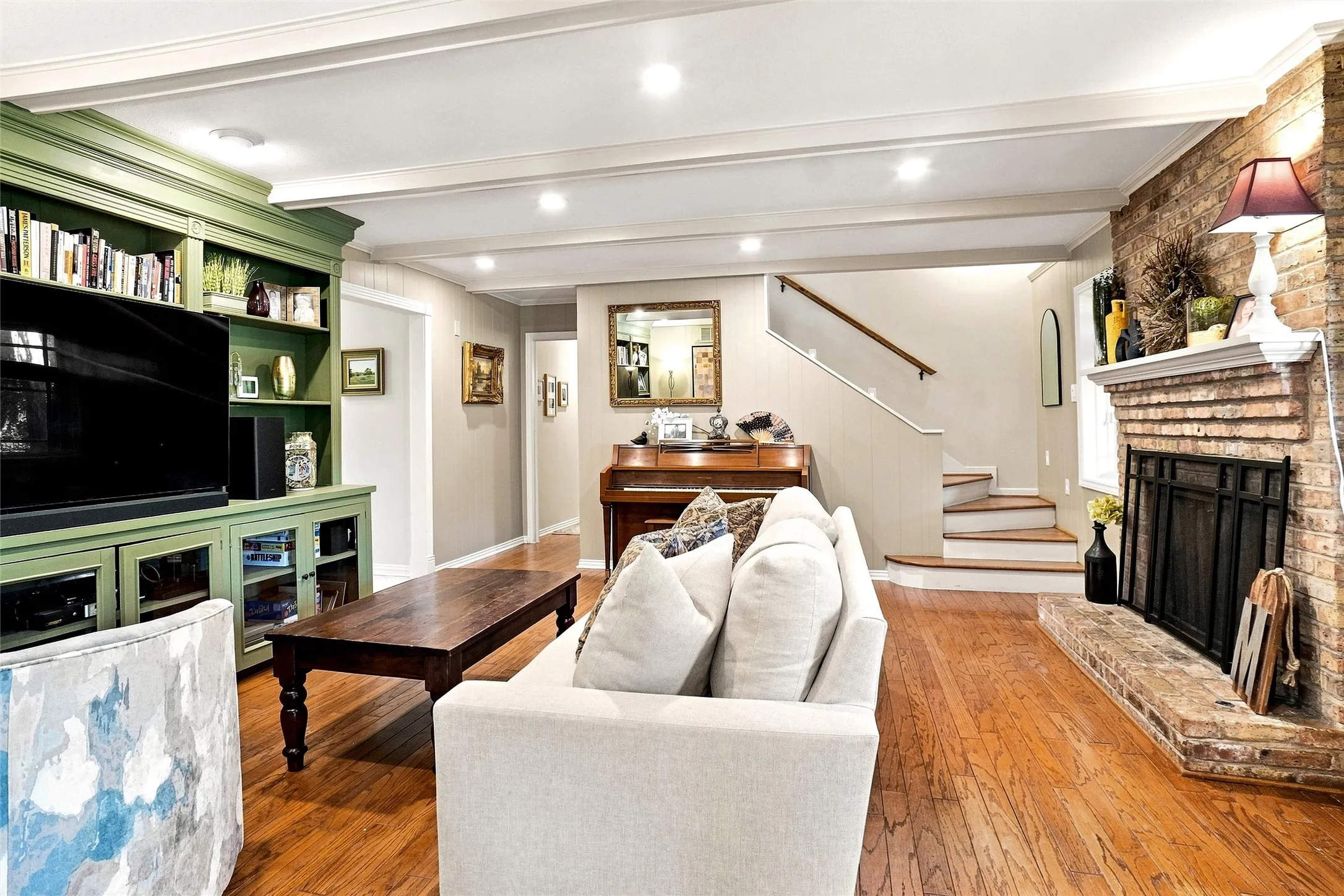  Inside, the home retains an abundance of its original Mid-Century charm, complemented by beautiful wood floors, custom built-ins, oak stair risers, and a striking illuminated staircase.