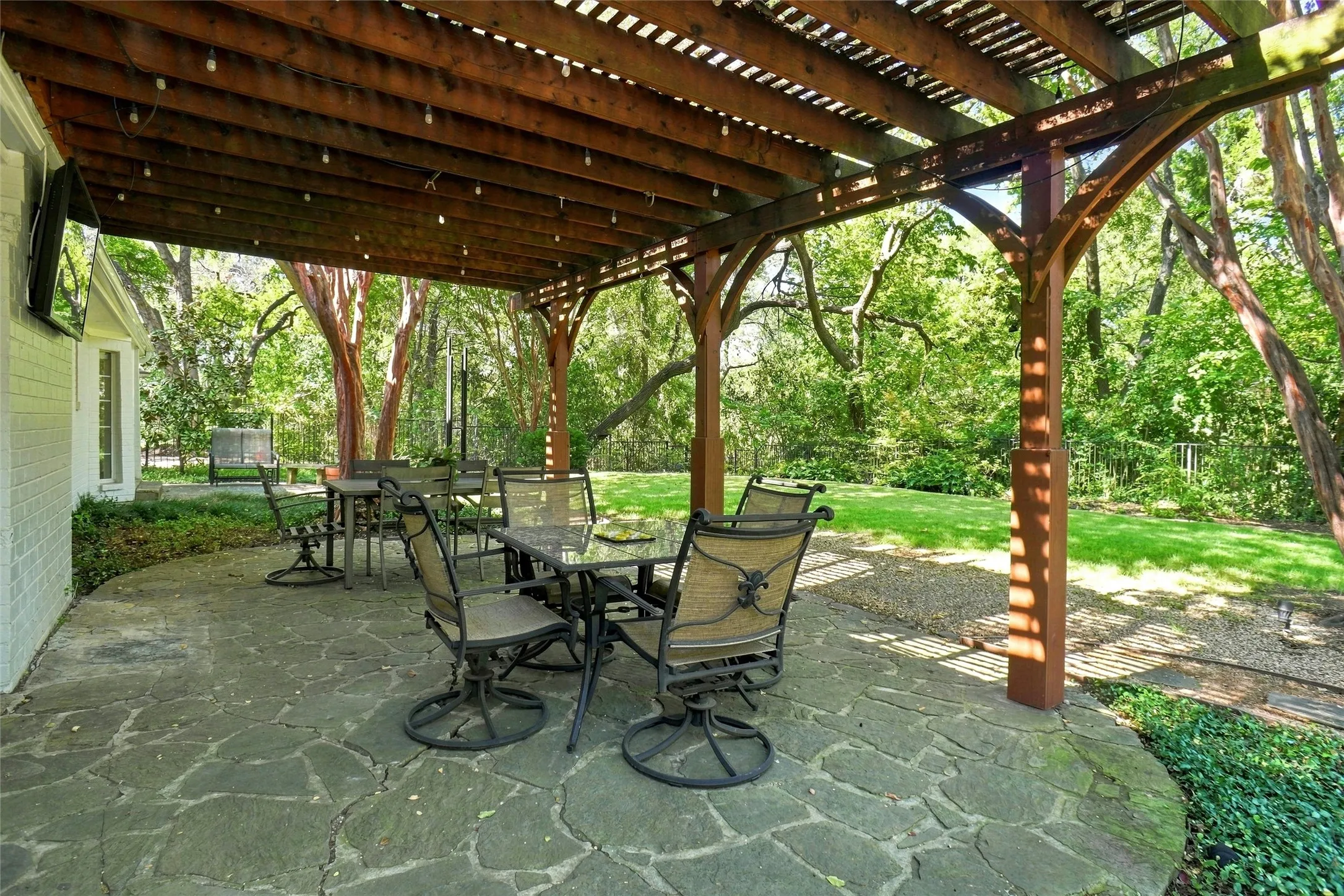 Beyond the home, the setting becomes even more special. The backyard backs to a peaceful creek and feels like a private garden retreat, with a Pergola covered flagstone patio surrounded by mature trees and natural beauty. It is a remarkably serene oasis—and hard to believe you are in the city.