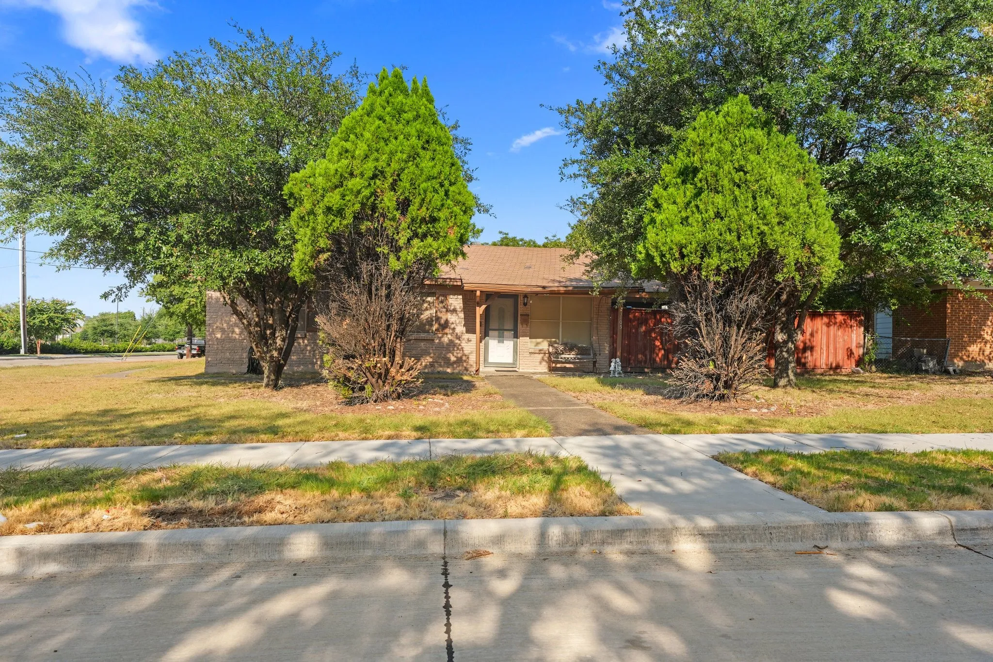 Single-story residence with a front entry, featuring a shingle roof and a concrete walkway