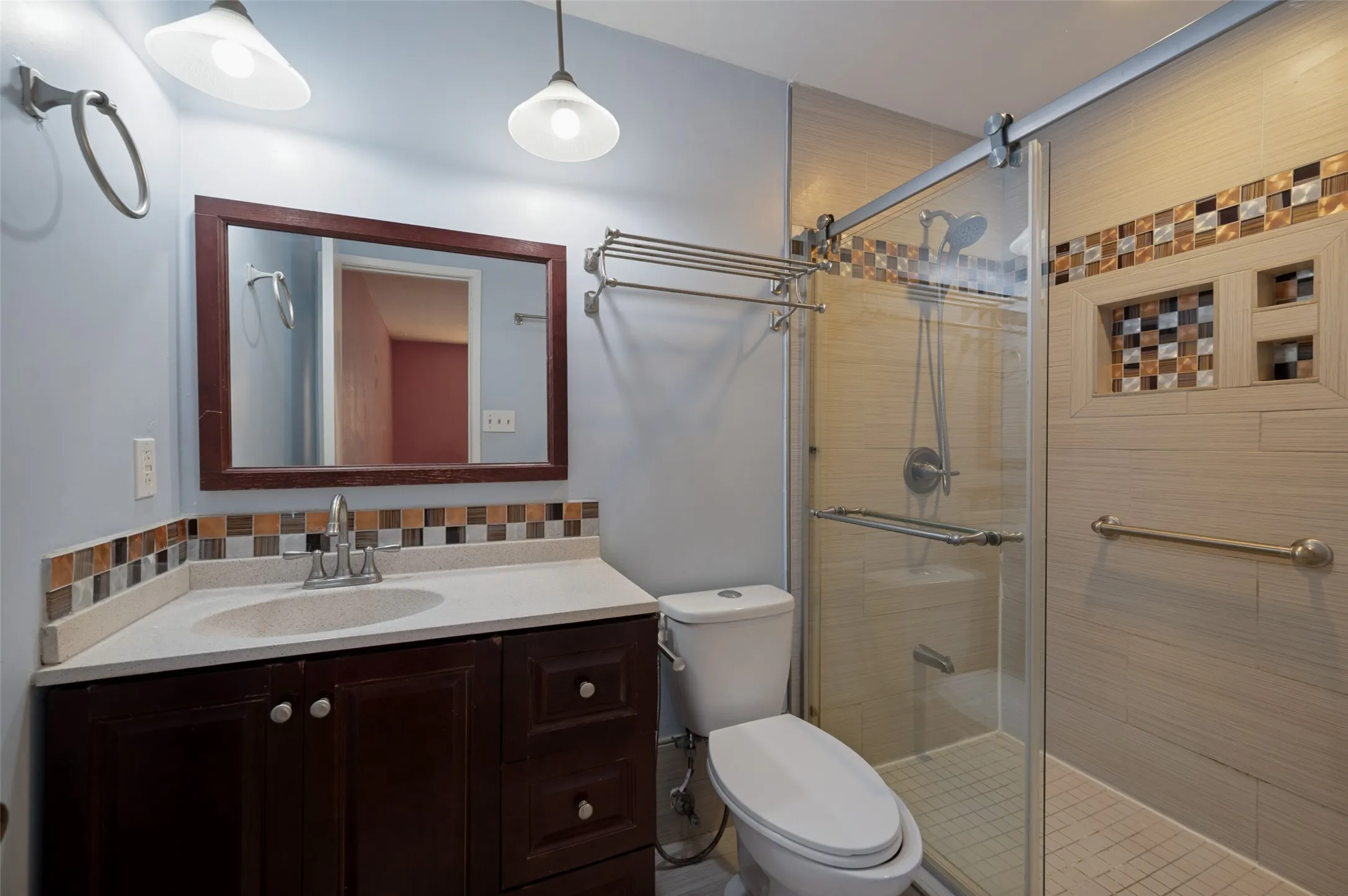 Vanity with integrated sink, framed mirror, and mosaic tile backsplash