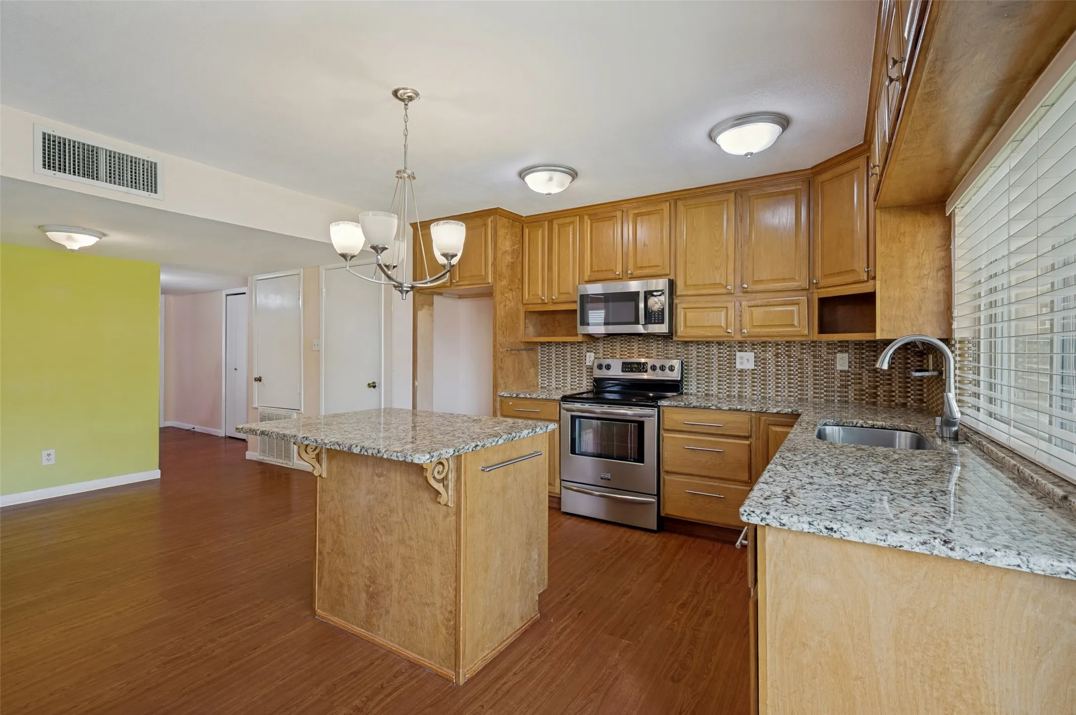 Kitchen featuring wood-finish cabinetry, stainless steel appliances, and stone countertops