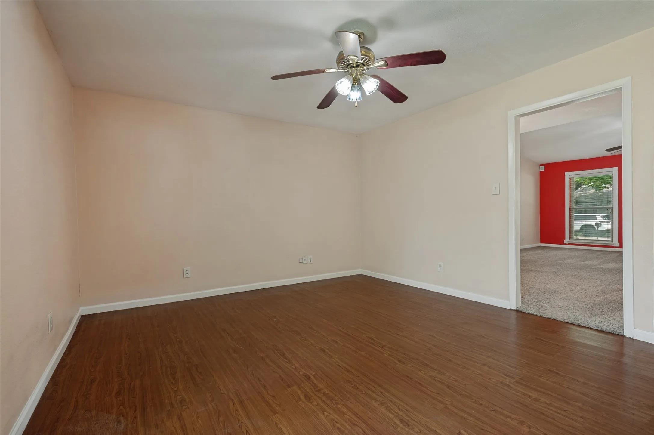 Wood-finish flooring, ceiling fan with light fixture, and neutral wall paint