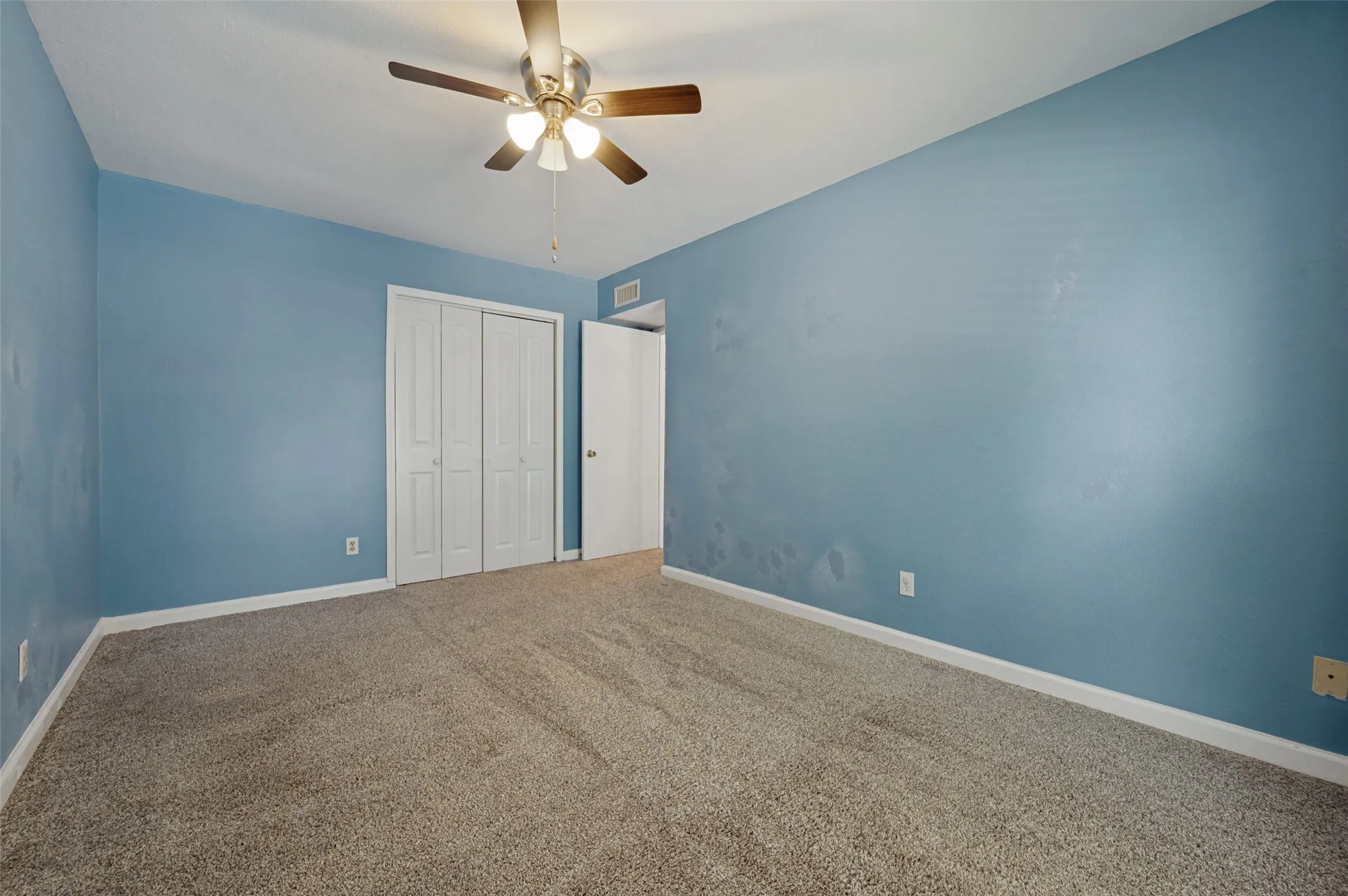 Carpeted flooring, bi-fold closet doors, ceiling fan with integrated lighting