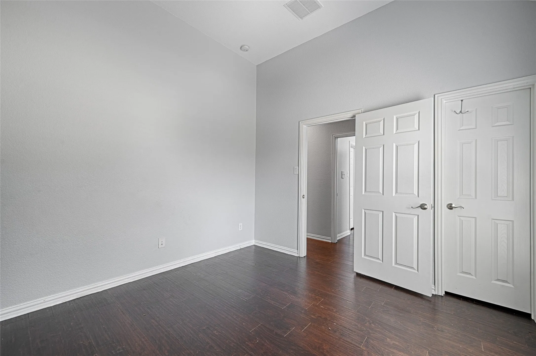 Vaulted ceiling with recessed lighting, wood-finish flooring, and paneled interior doors