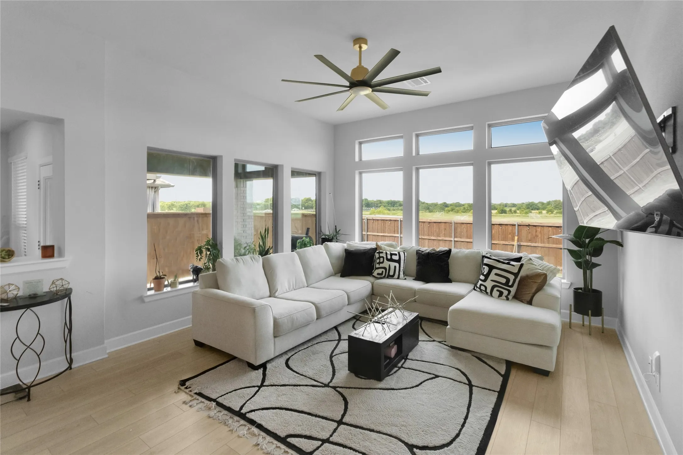 Vaulted ceilings, wood-finish flooring, and a contemporary ceiling fan