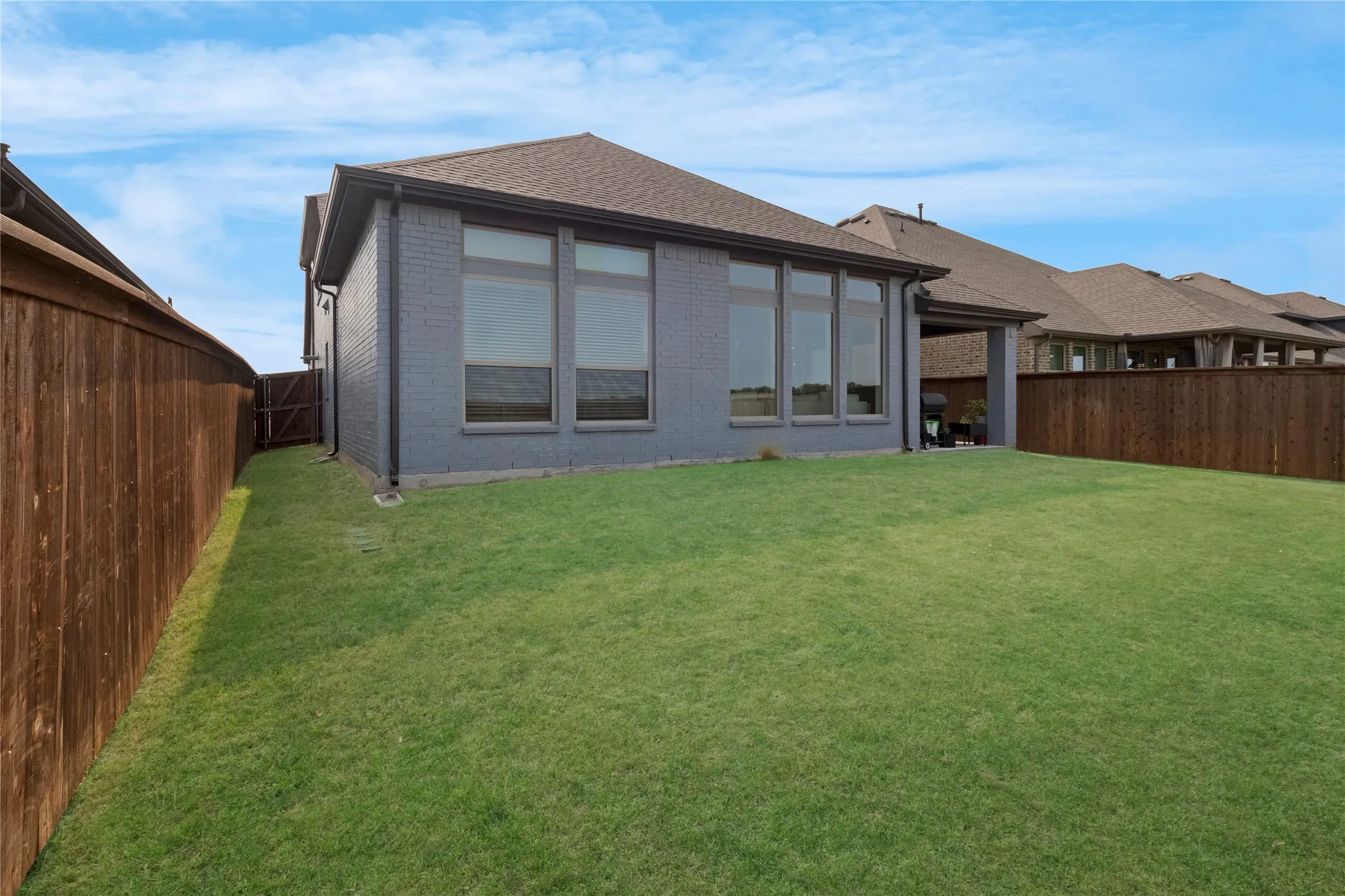 Expansive grassy yard with full privacy fencing