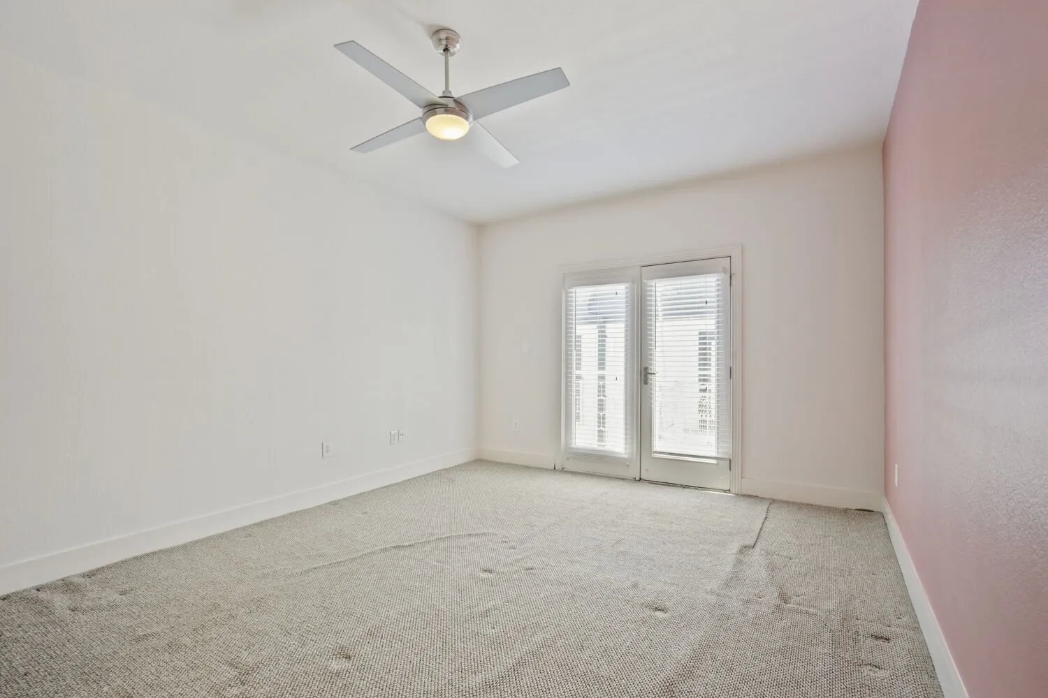 Recessed ceiling fan with integrated lighting, double French doors, light-colored carpeting, and a contrasting accent wall