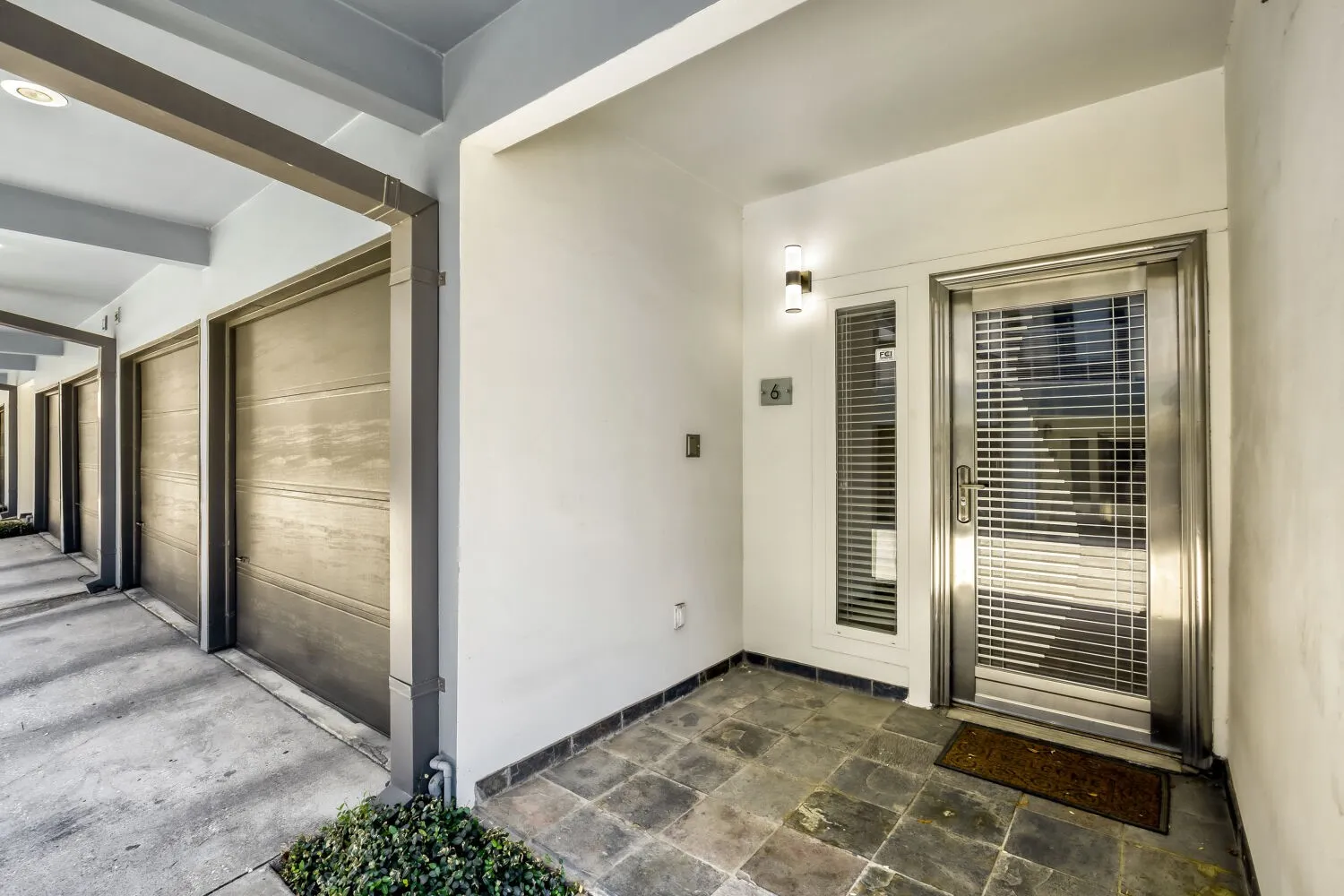 Entryway with natural stone flooring, brushed metal entry door, and integrated sidelight