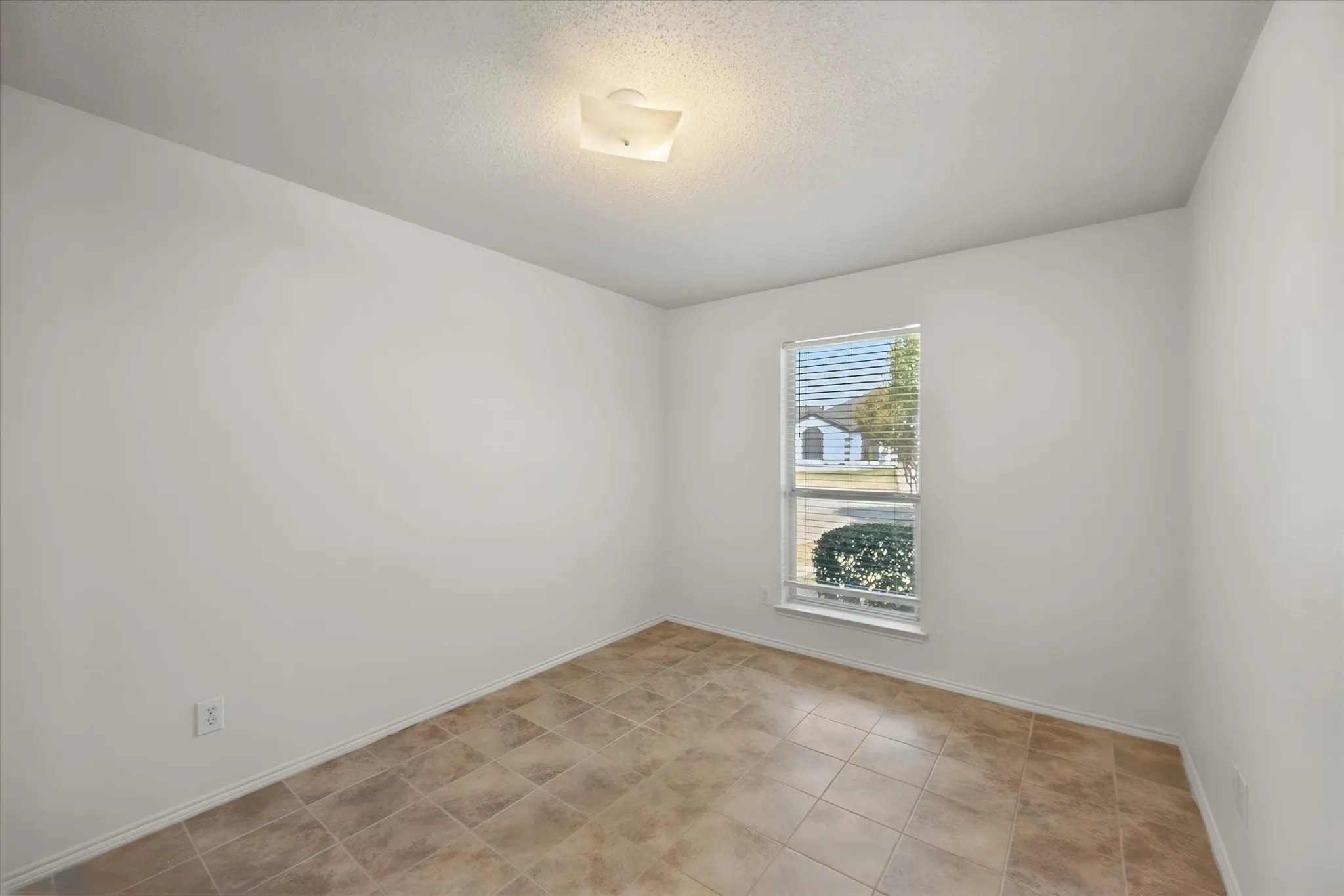 Recessed window with blinds, overhead flush-mount light fixture, and tile flooring