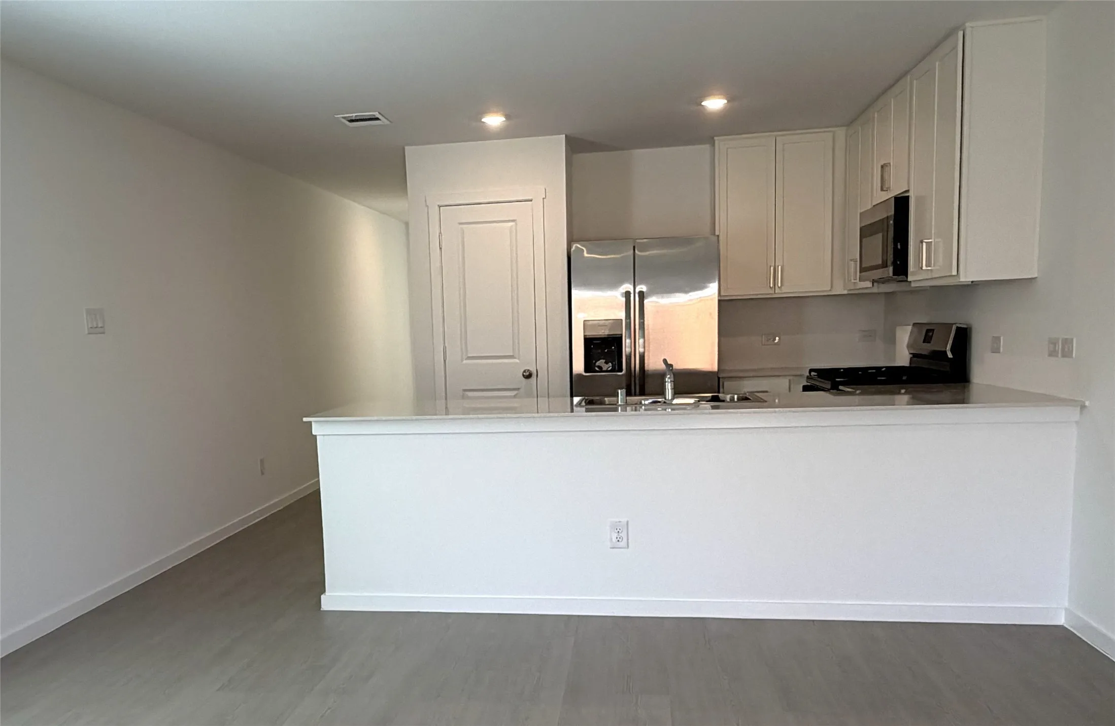 Kitchen featuring stainless steel appliances, white cabinetry, and kitchen Island
