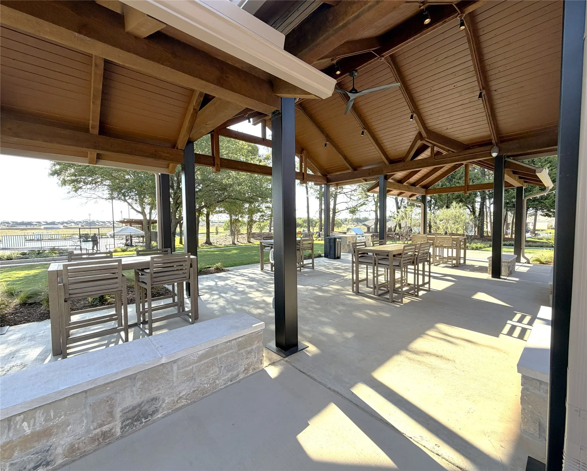 CommunityL Expansive covered patio featuring a wood-finish ceiling, exposed beams, and integrated lighting