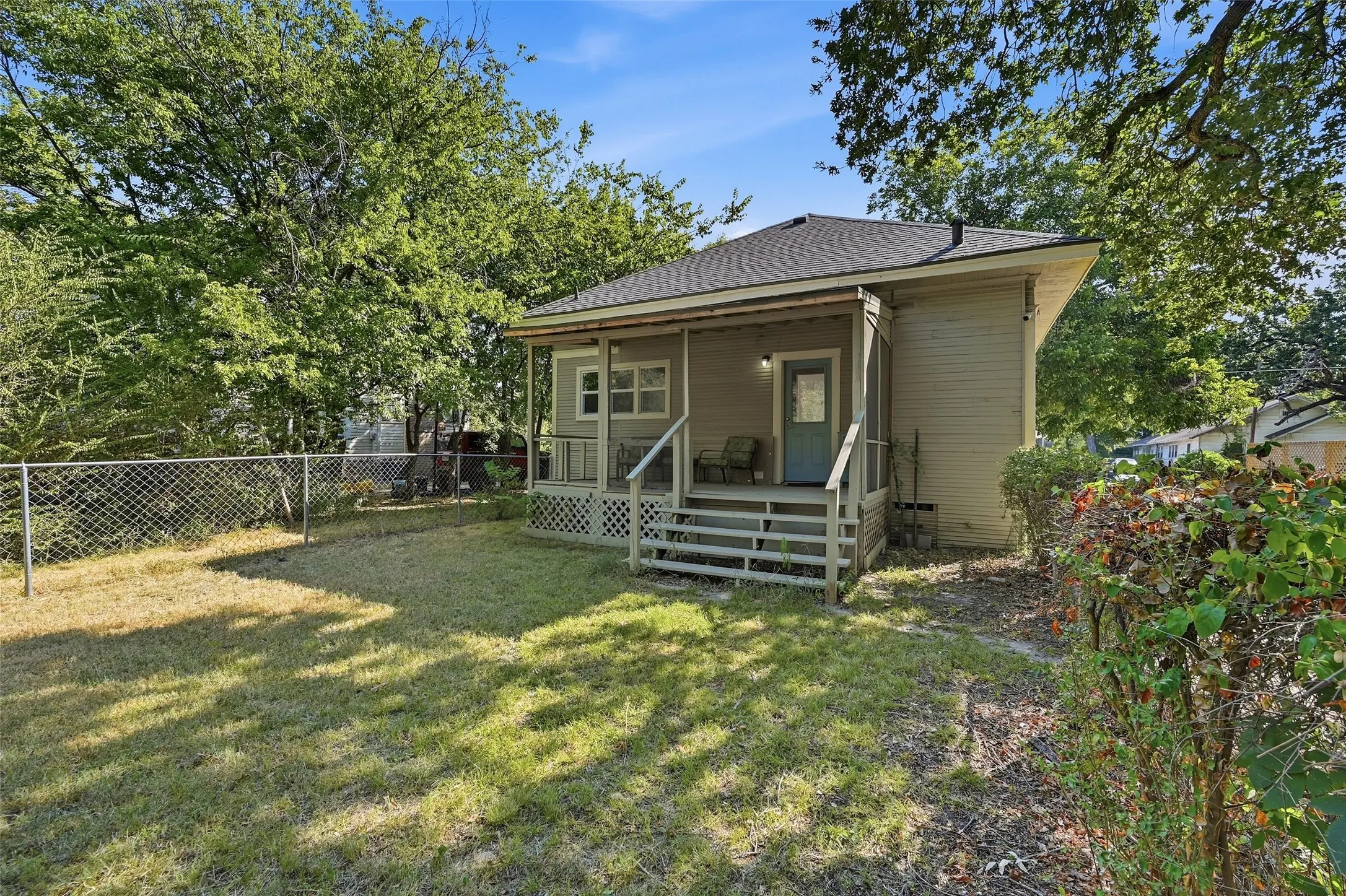 Backyard featuring a chain-link fence and mature trees