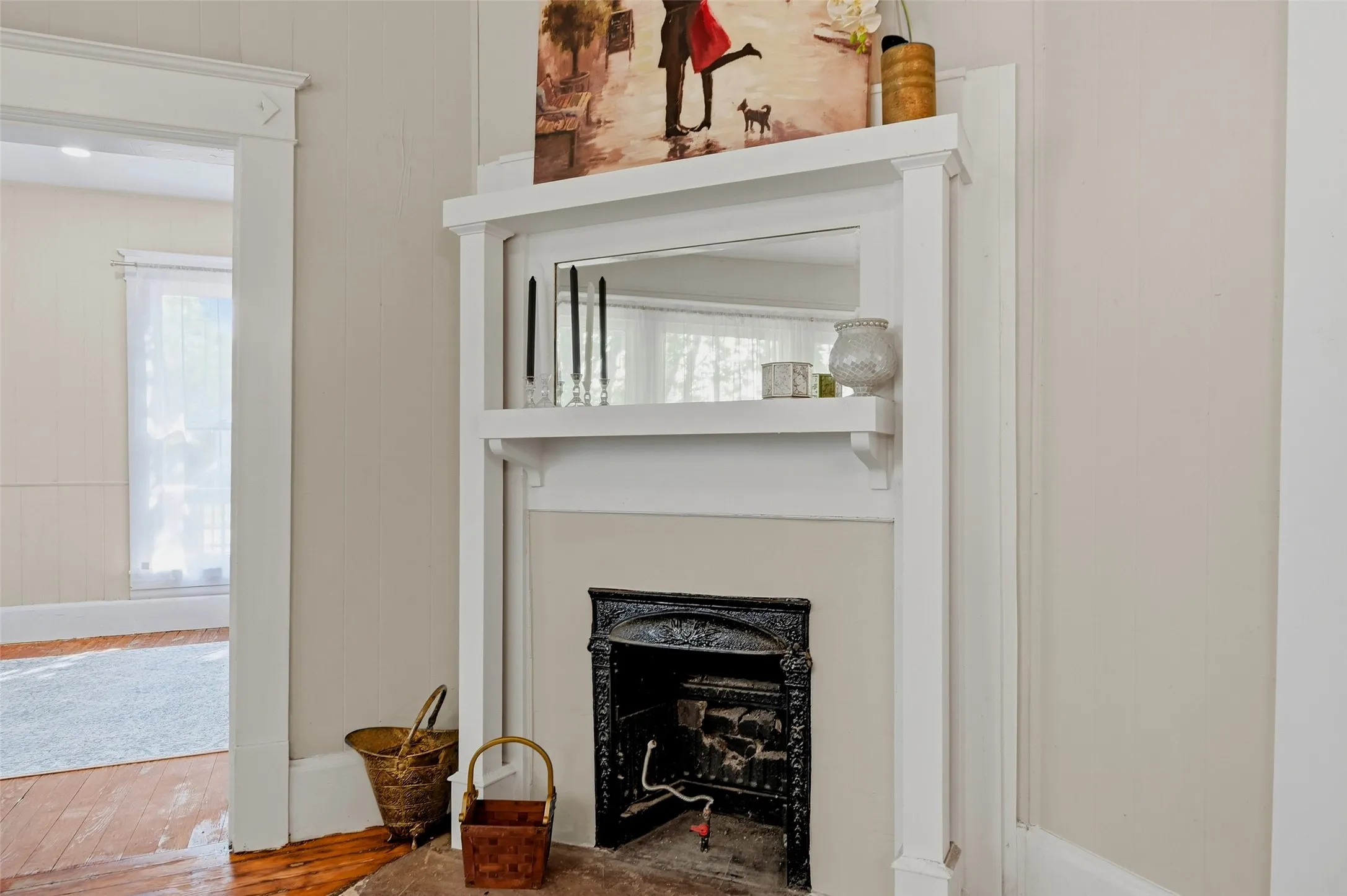 Fireplace featuring a traditional cast iron insert and a white wood mantel