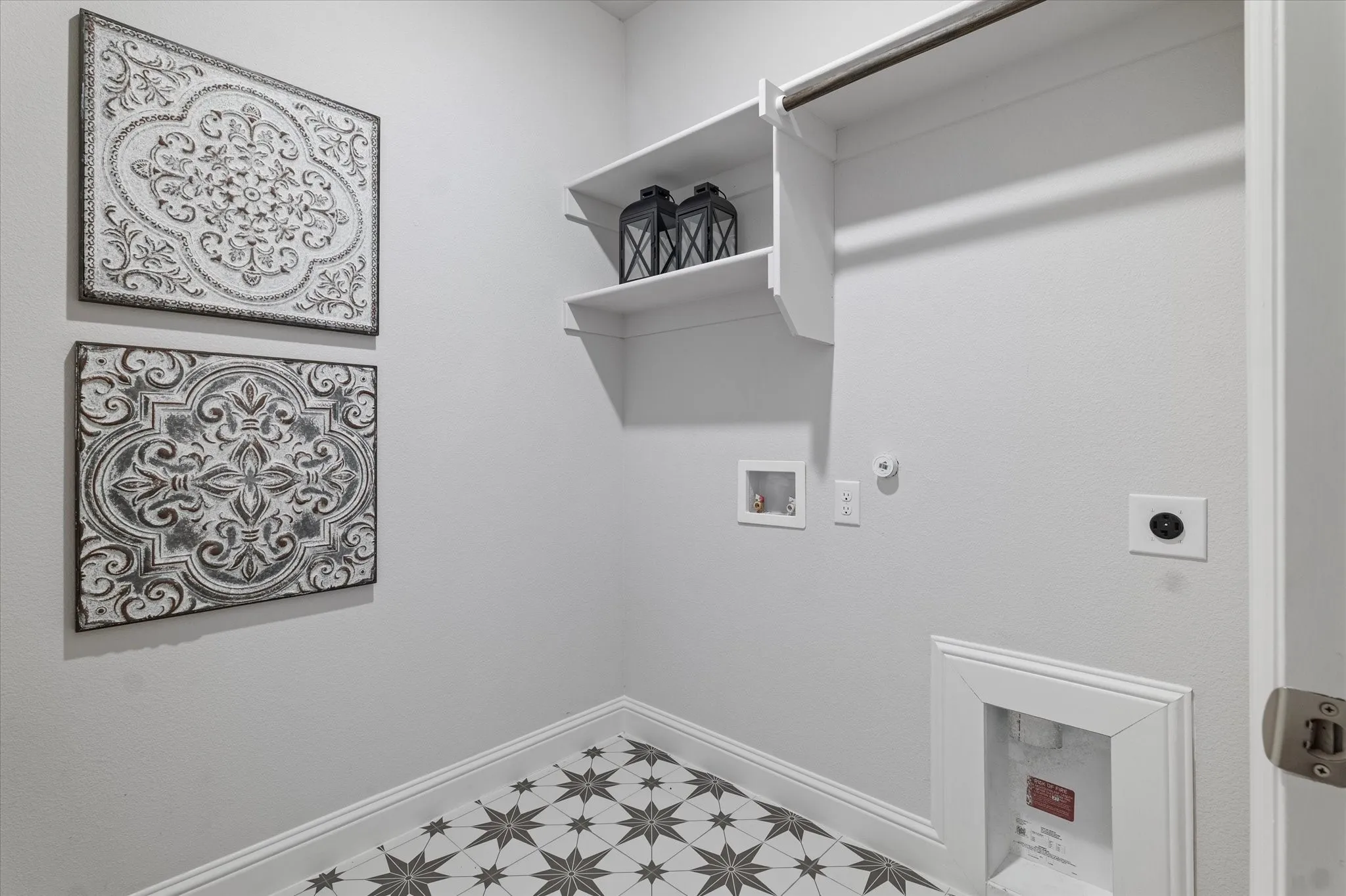 Laundry area featuring patterned tile flooring, built-in shelving, and a garment hanging rod