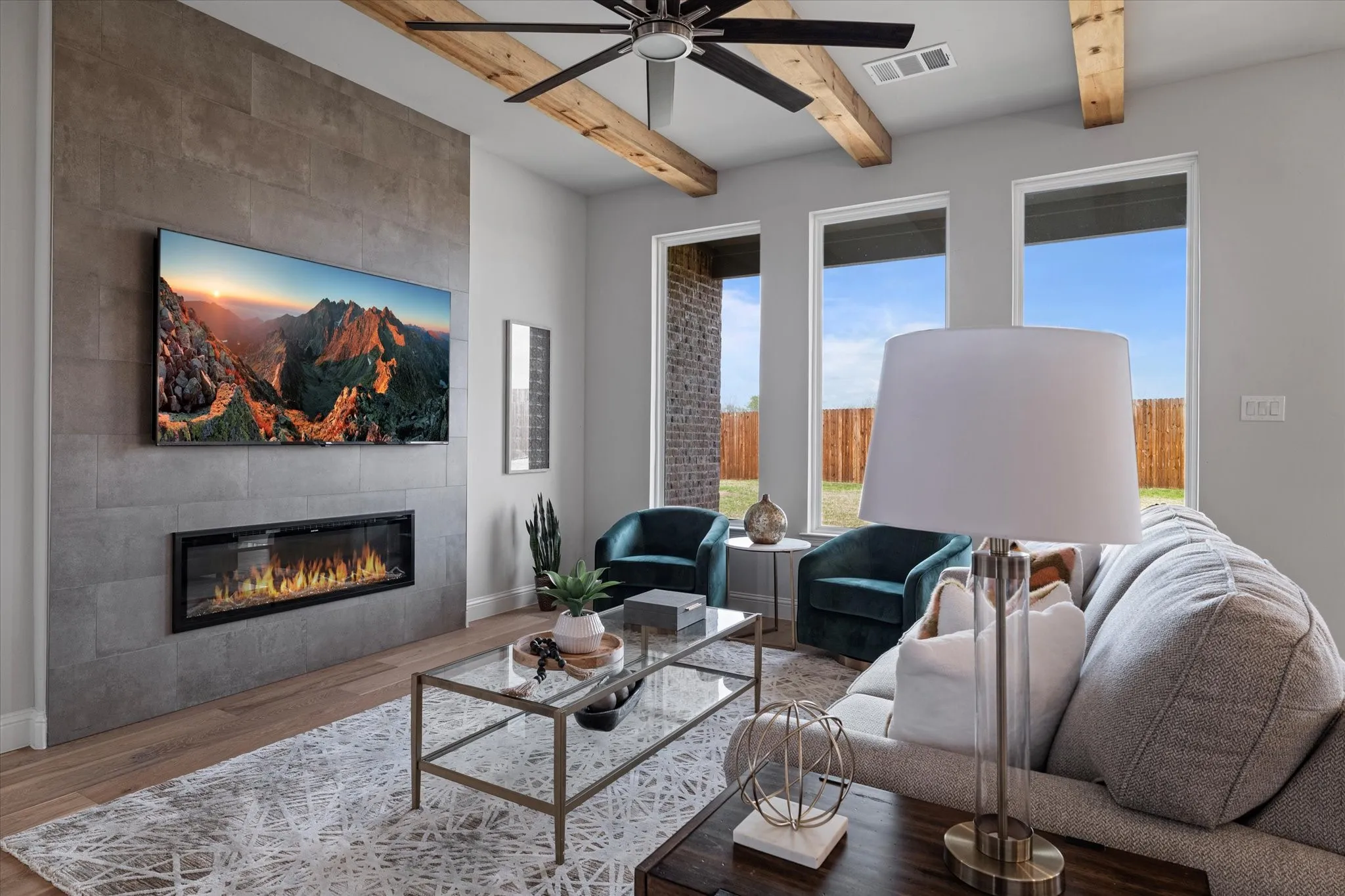 Wood flooring, exposed ceiling beams, and a modern ceiling fan