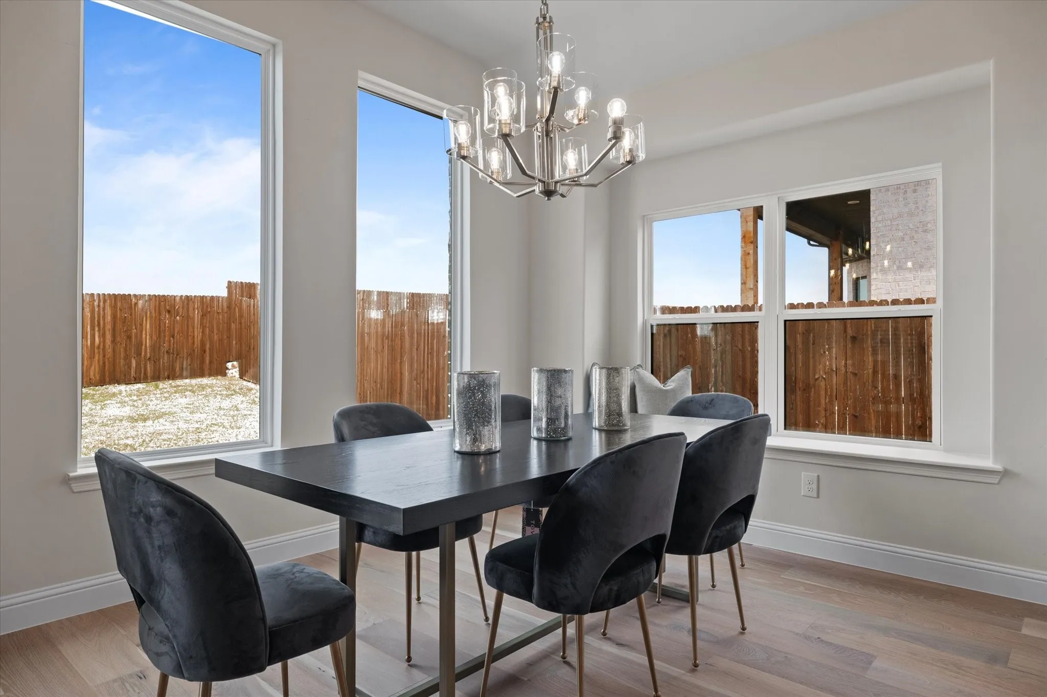 Recessed lighting, wood- flooring, multiple windows, and a contemporary chandelier