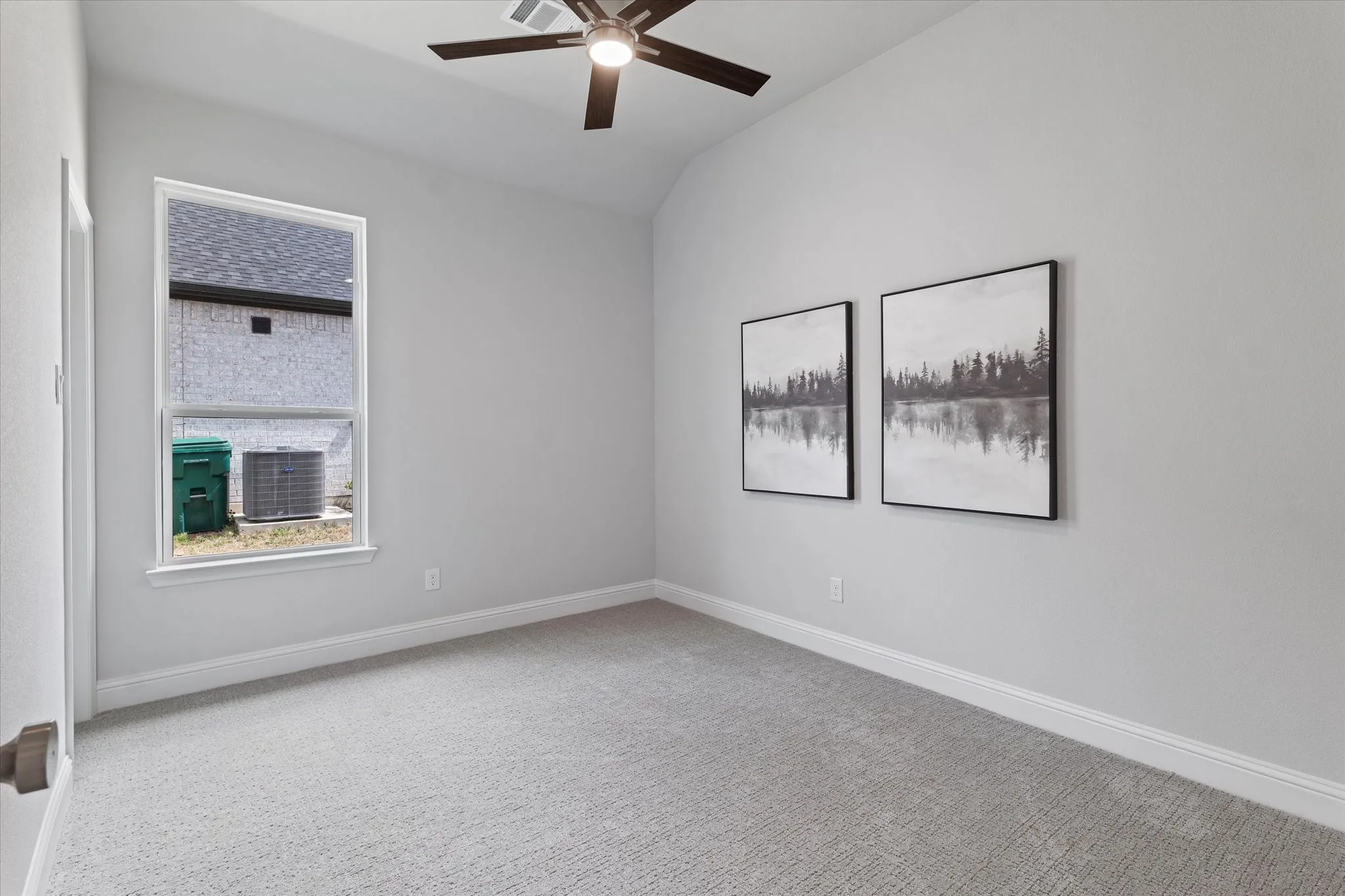 Vaulted ceiling, ceiling fan, white walls, carpeted flooring, and a single-pane window