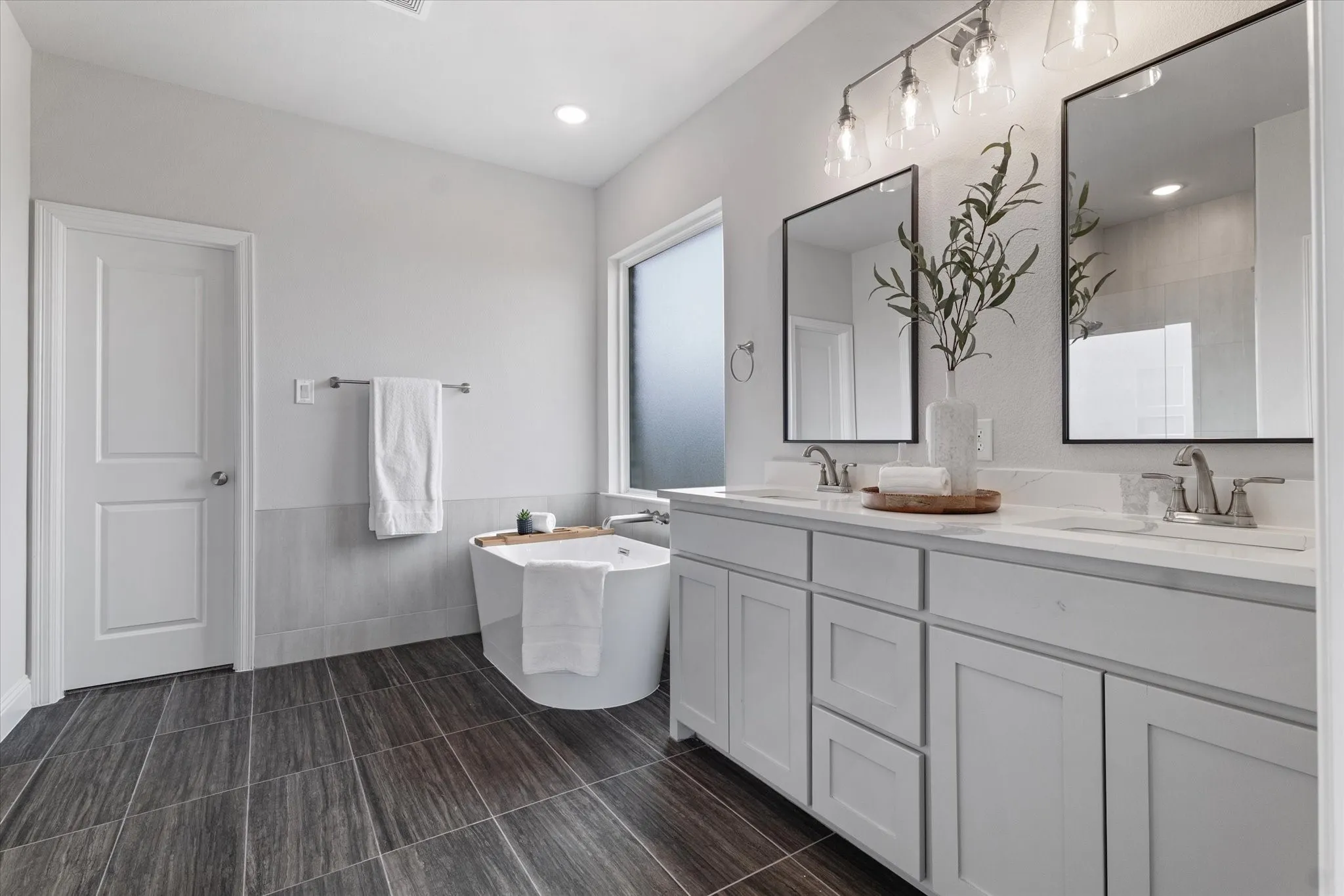 Dual vanity with undermount sinks, white cabinetry, and framed mirrors