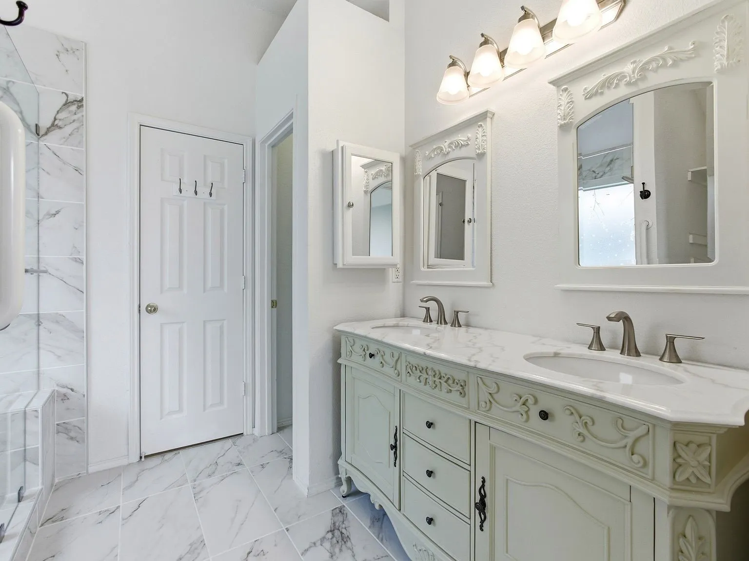 Dual vanity with custom cabinetry, undermount sinks, and brushed nickel fixtures
