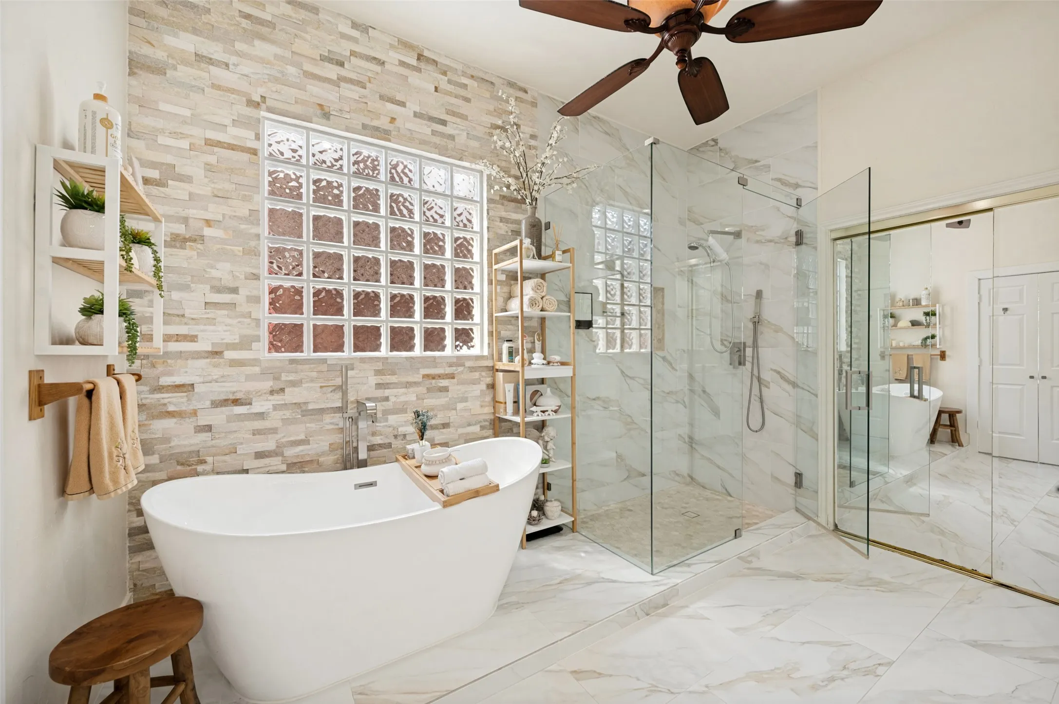 Spa like soaking tub, floor-to-ceiling tiled accent wall with glass block window, frameless shower and a walk-in closet