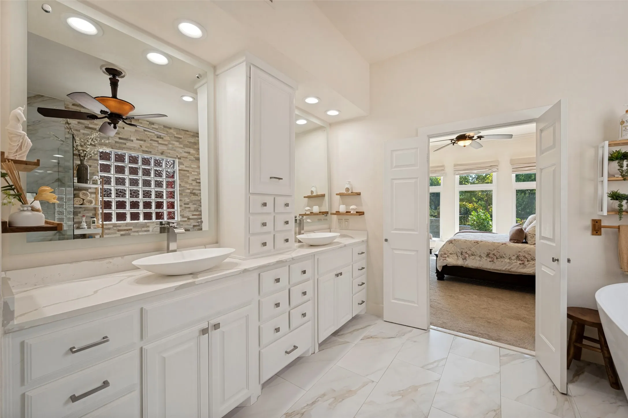 Dual vanity with vessel sinks, white cabinetry, stone-finish countertops and white tile flooring.