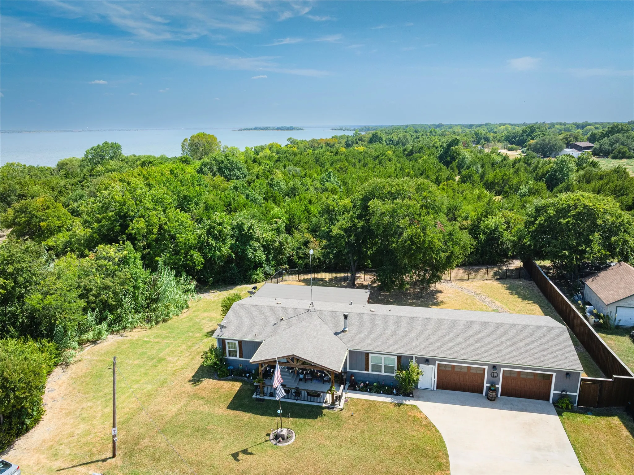 Single-story residence featuring a covered front porch, attached two-car garage with wood-finish doors, and a concrete driveway