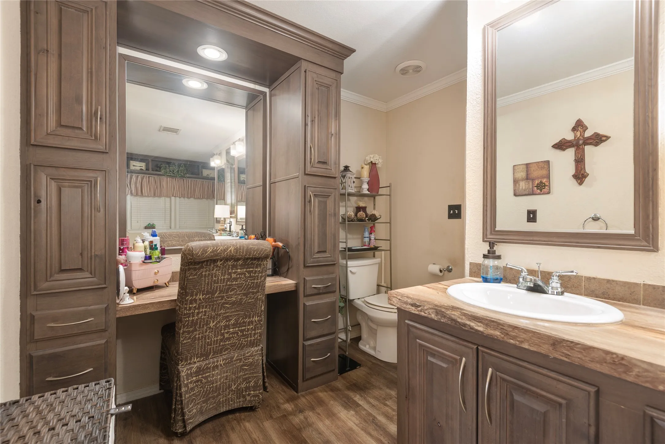 Built-in vanity with integrated mirror, wood-finish cabinetry, recessed lighting, and wood-finish flooring
