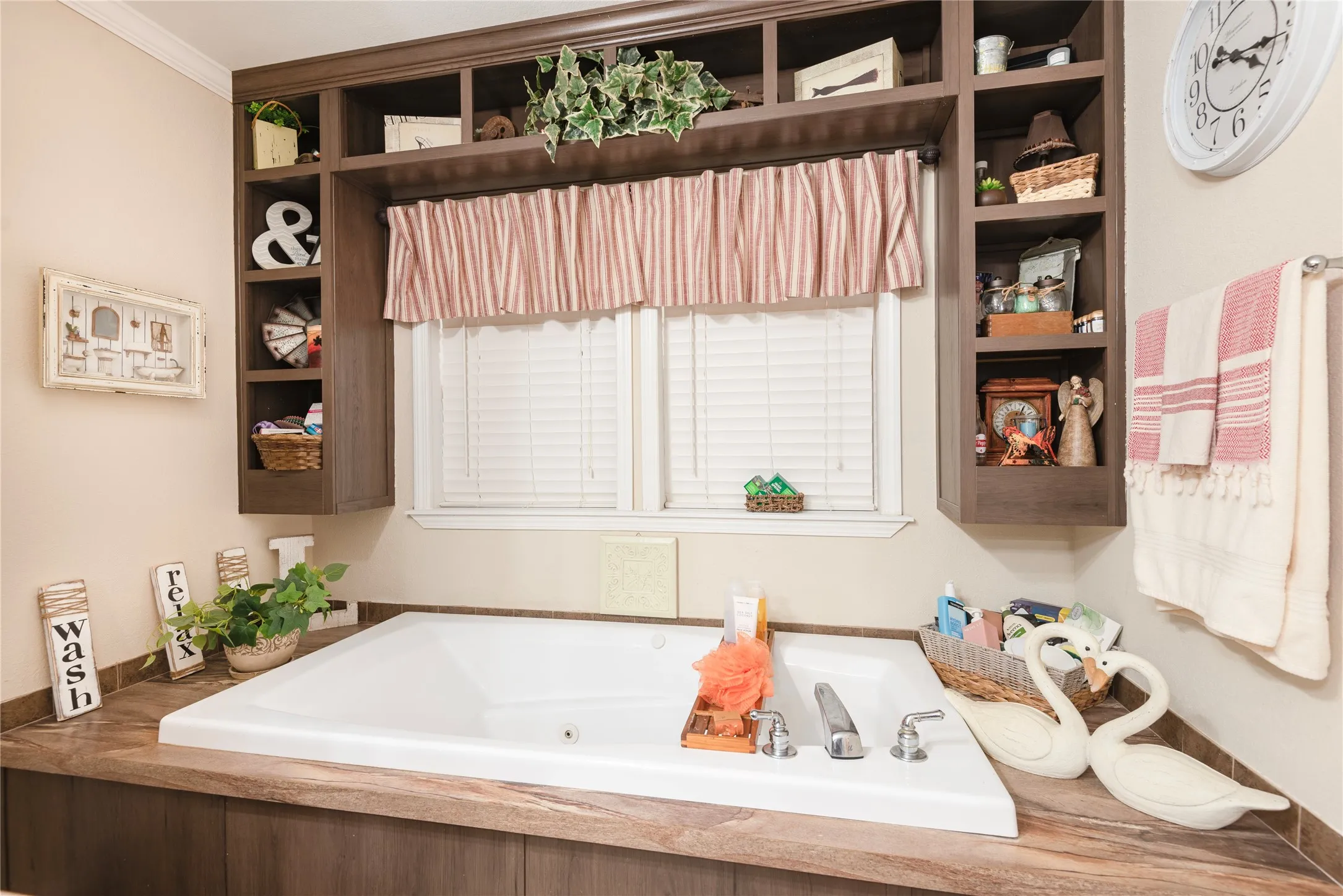 Built-in jetted tub with chrome fixtures, wood-finish surround, and integrated shelving