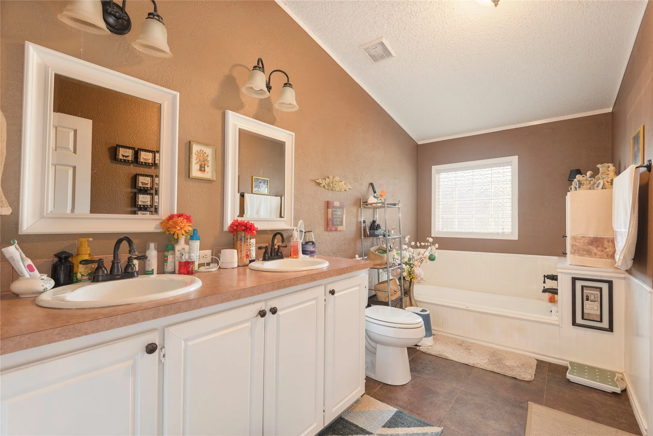 Double vanity with white cabinetry, dual undermount sinks, and wall-mounted mirrors