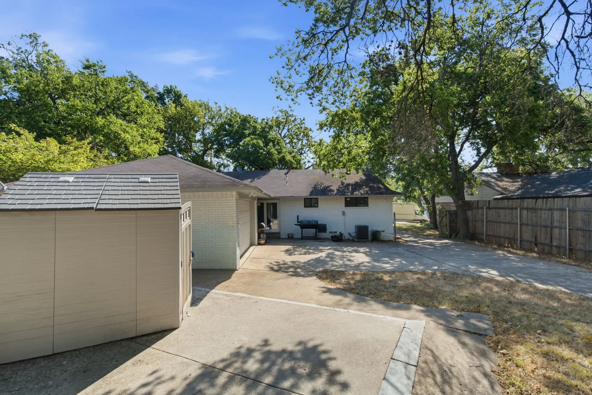 Driveway and Detached Garage with Metal RoofWell-maintained single-story residence featuring a spacious driveway and detached garage with a metal roof