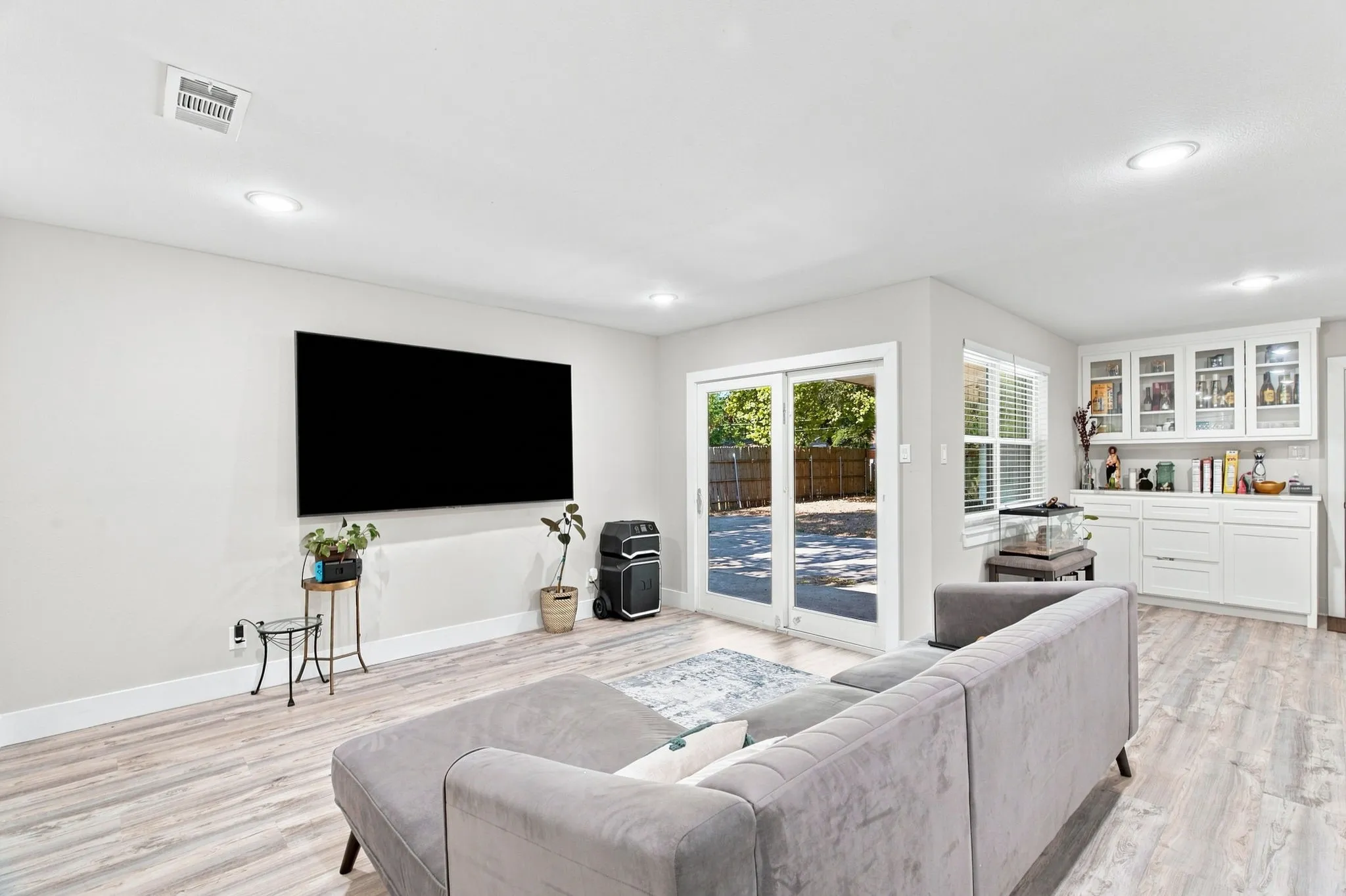 Recessed lighting, wood-finish flooring, sliding glass doors, built-in cabinetry, and window with blinds