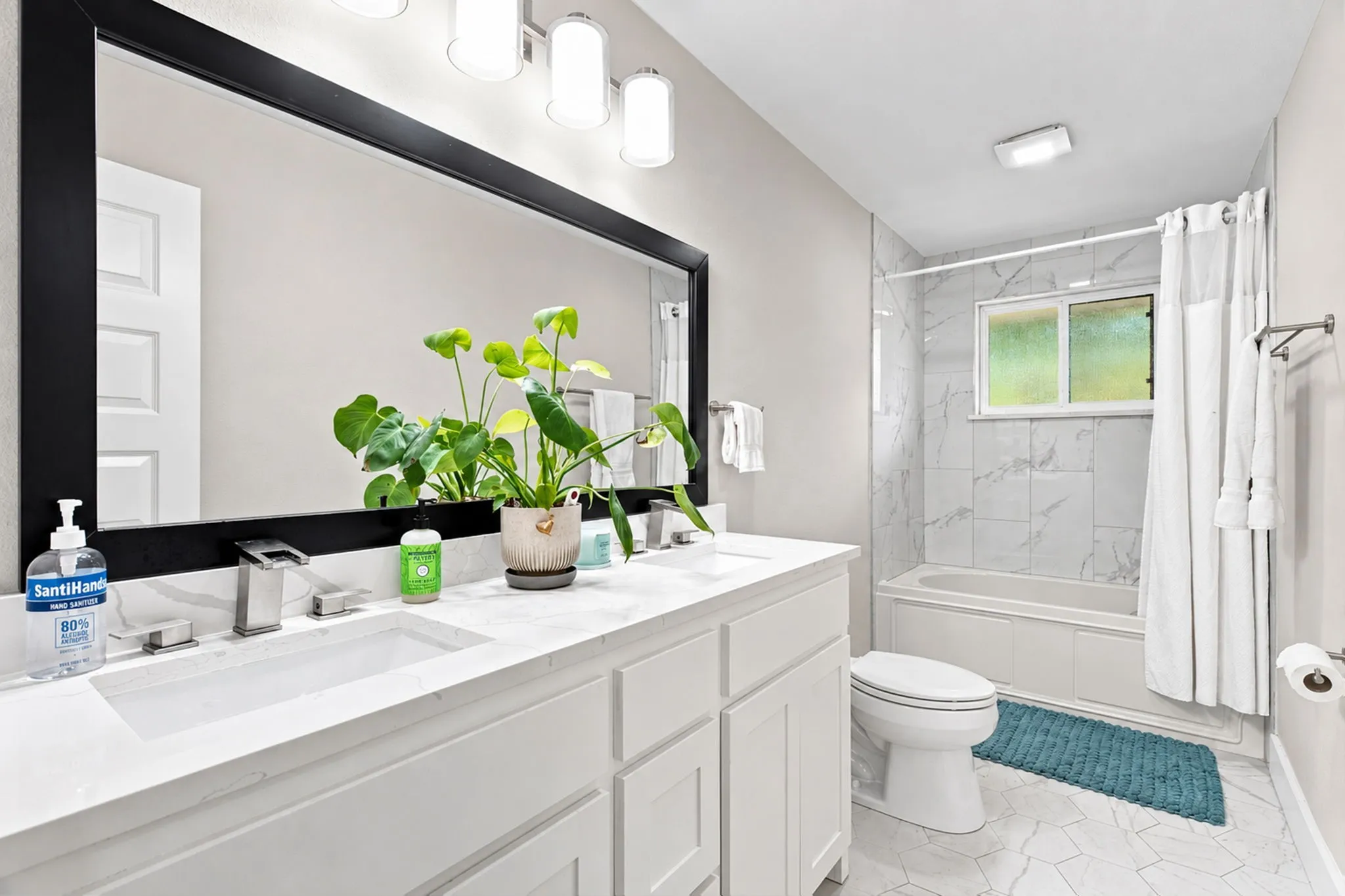 Dual vanity with integrated sinks, brushed nickel faucets, and a large framed mirror