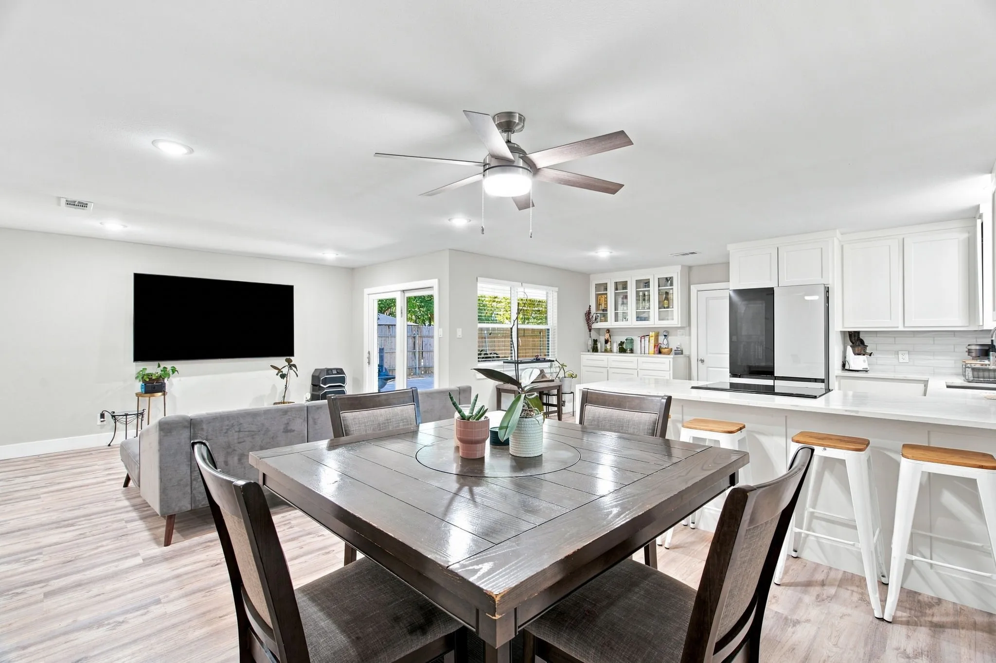 Open-concept living area with wood-finish flooring, recessed lighting, and a ceiling fan