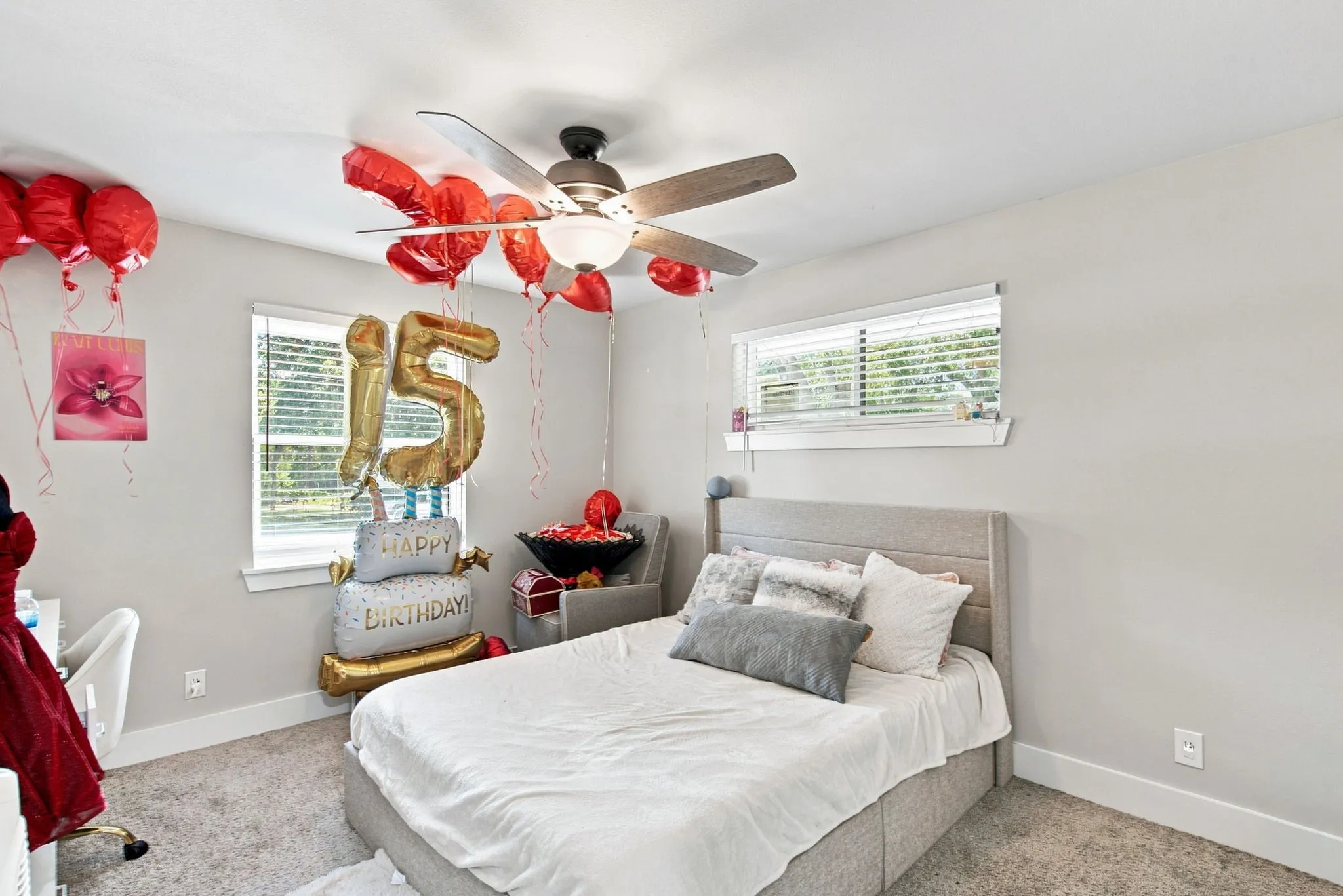 Carpeted room featuring a ceiling fan with integrated lighting, two windows with blinds, and light-toned walls