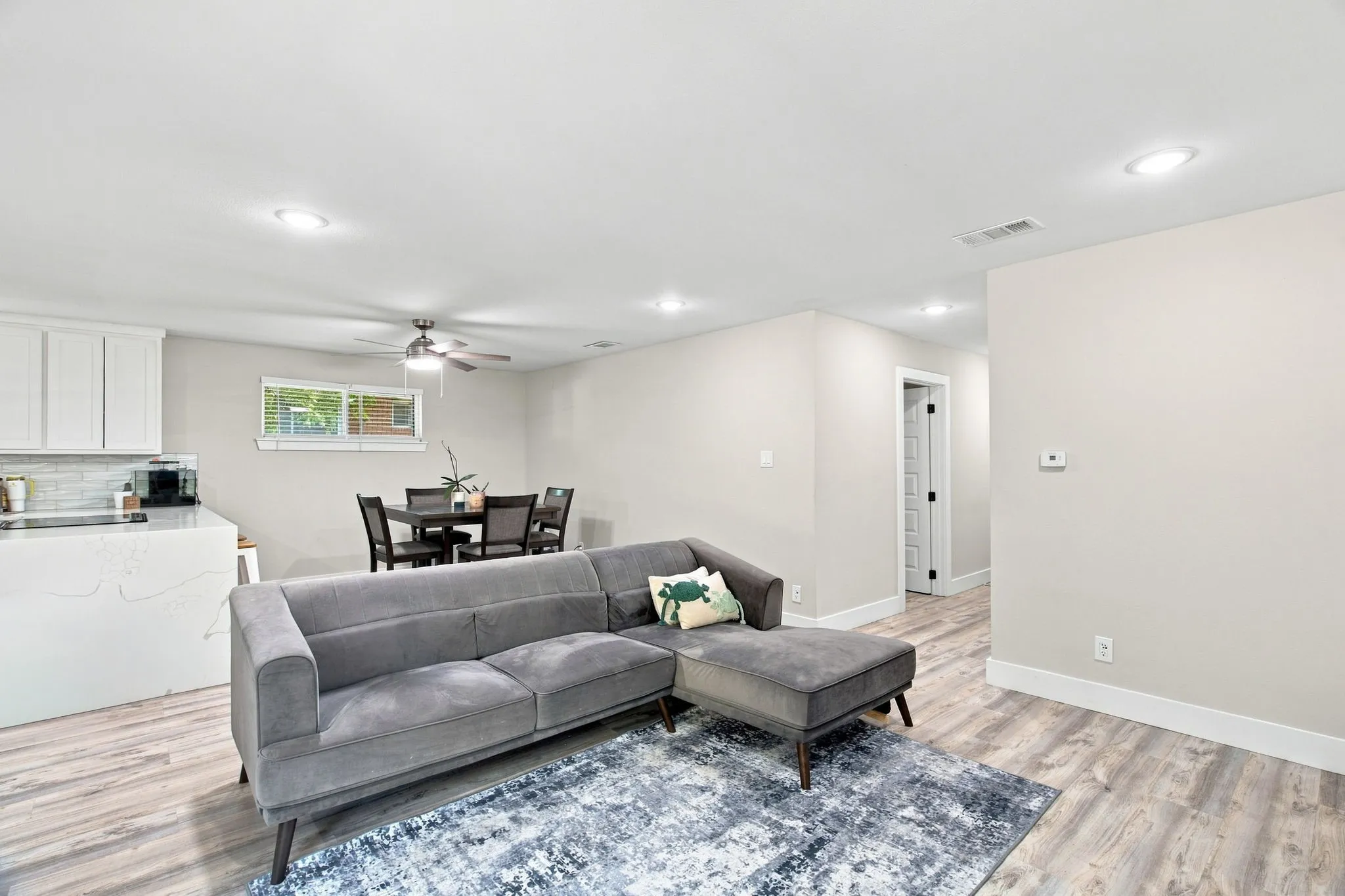 Open concept living space featuring wood-finish flooring, recessed lighting, and white baseboards