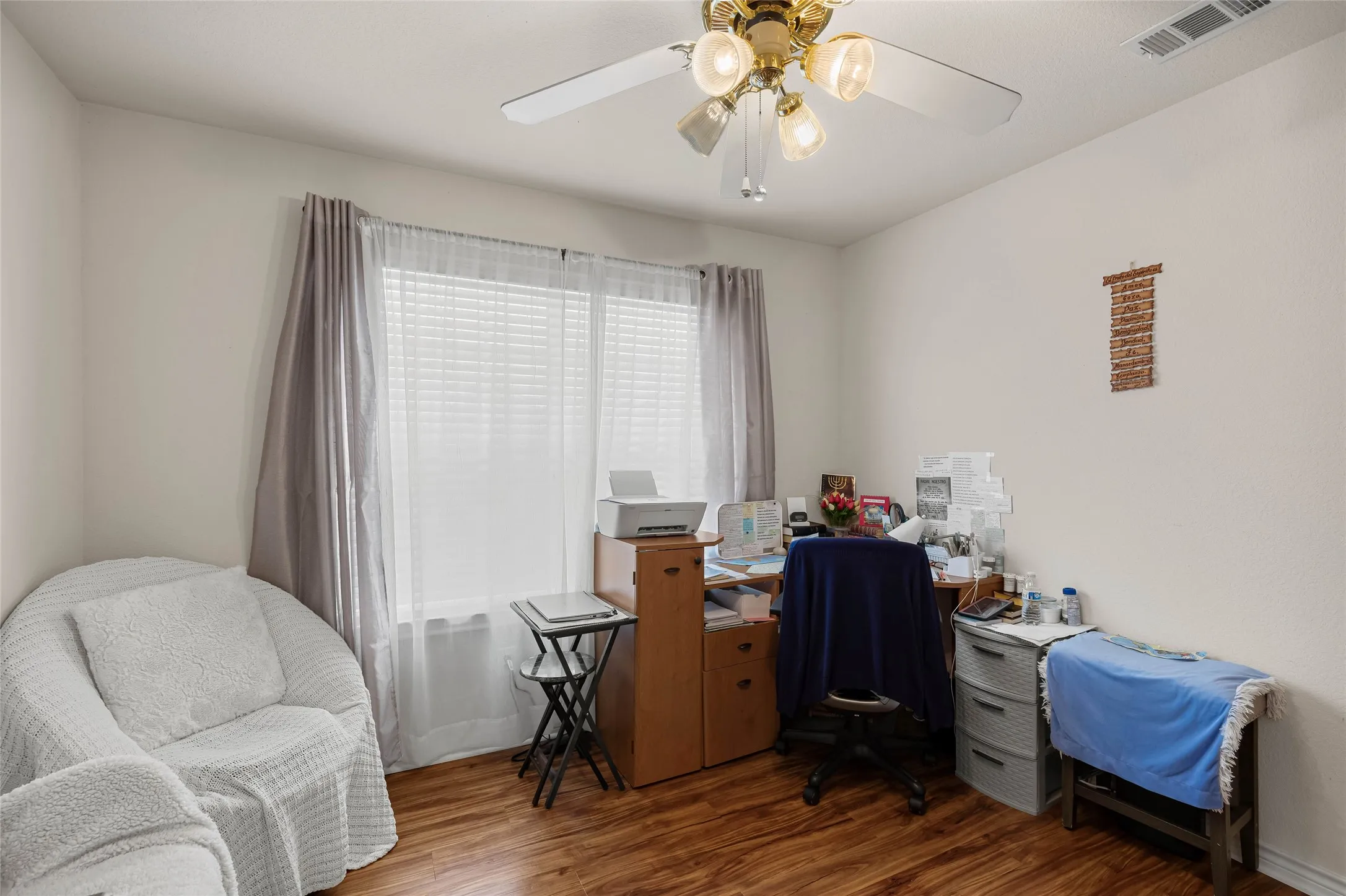 Secondary bedroom with large windows, currently used as an office.