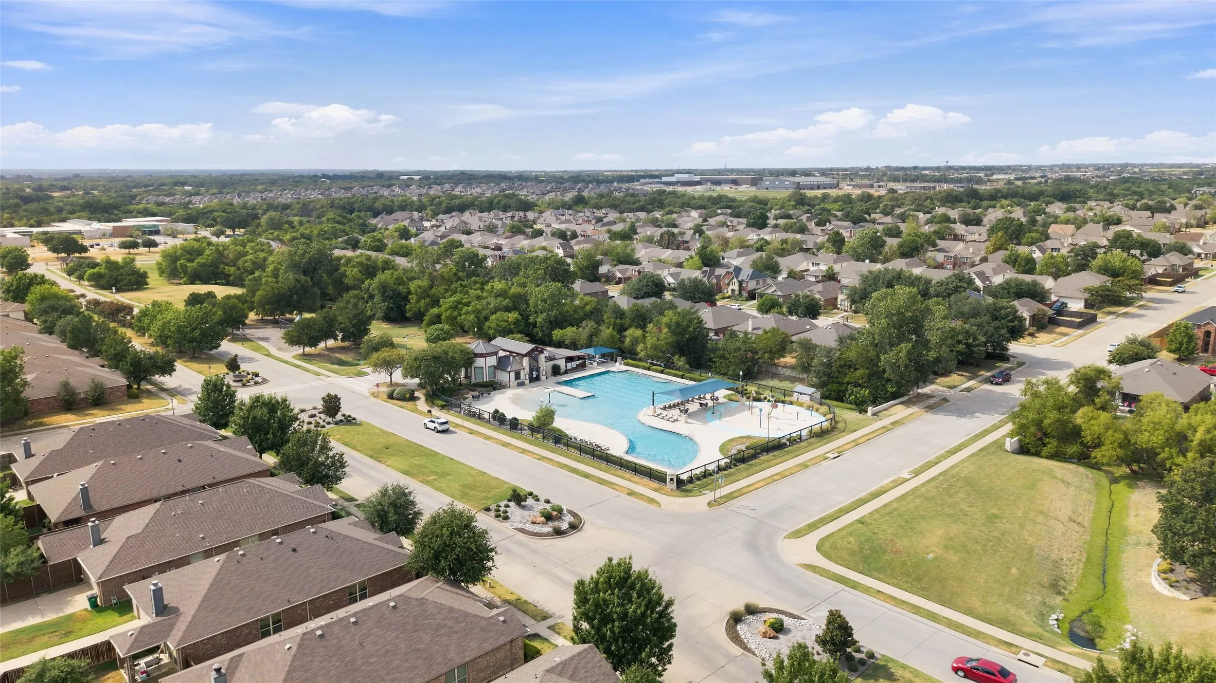 Community featuring a large outdoor swimming pool, paved pool deck, and a dedicated pool house structure