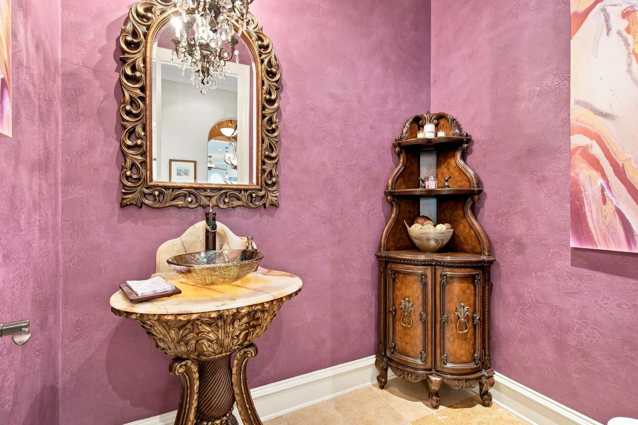 Ornate carved wood vanity with a vessel sink and stone countertop