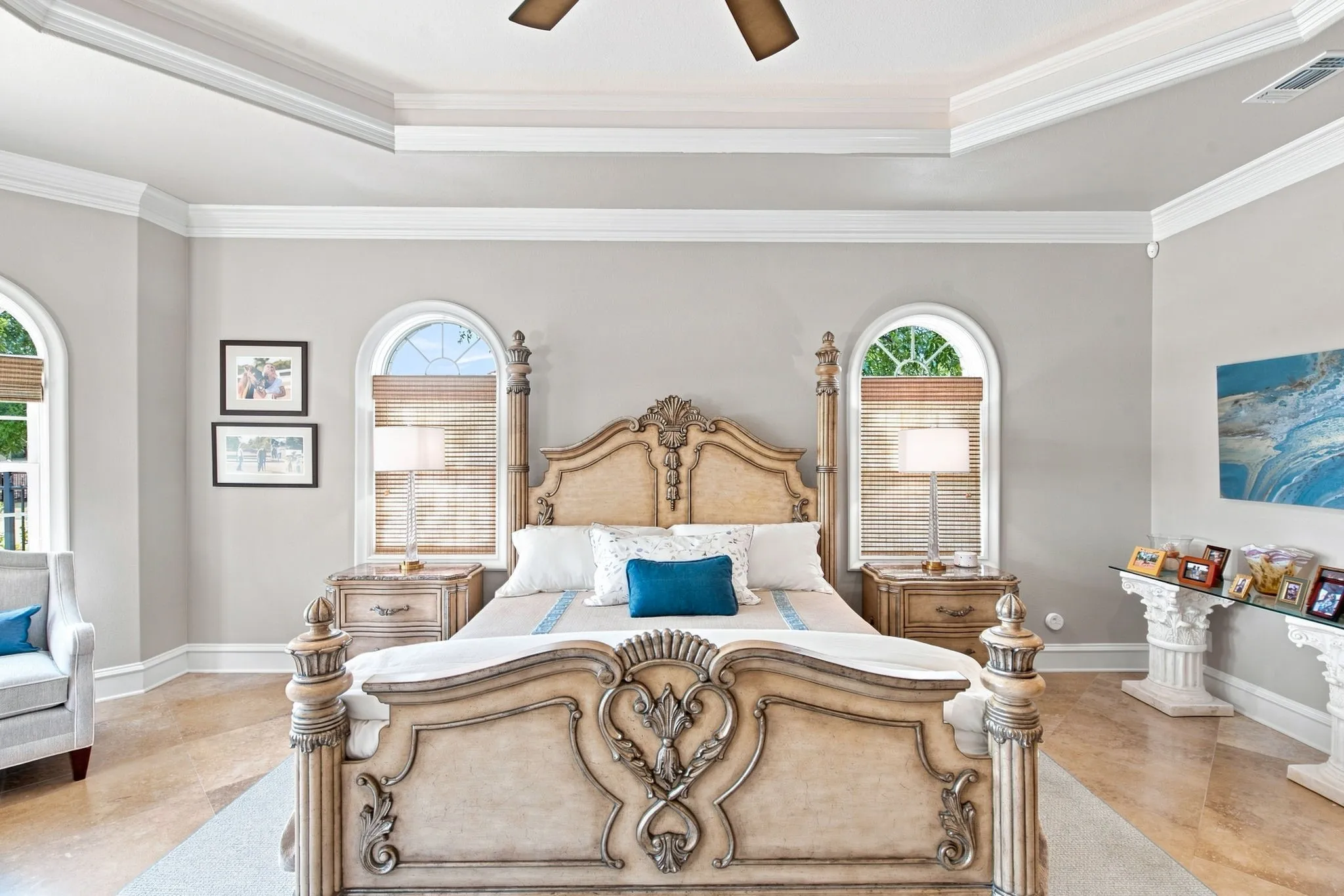 Arch-top windows, tray ceiling, crown molding, wood-finish flooring, and built-in display shelf with Corinthian column supports